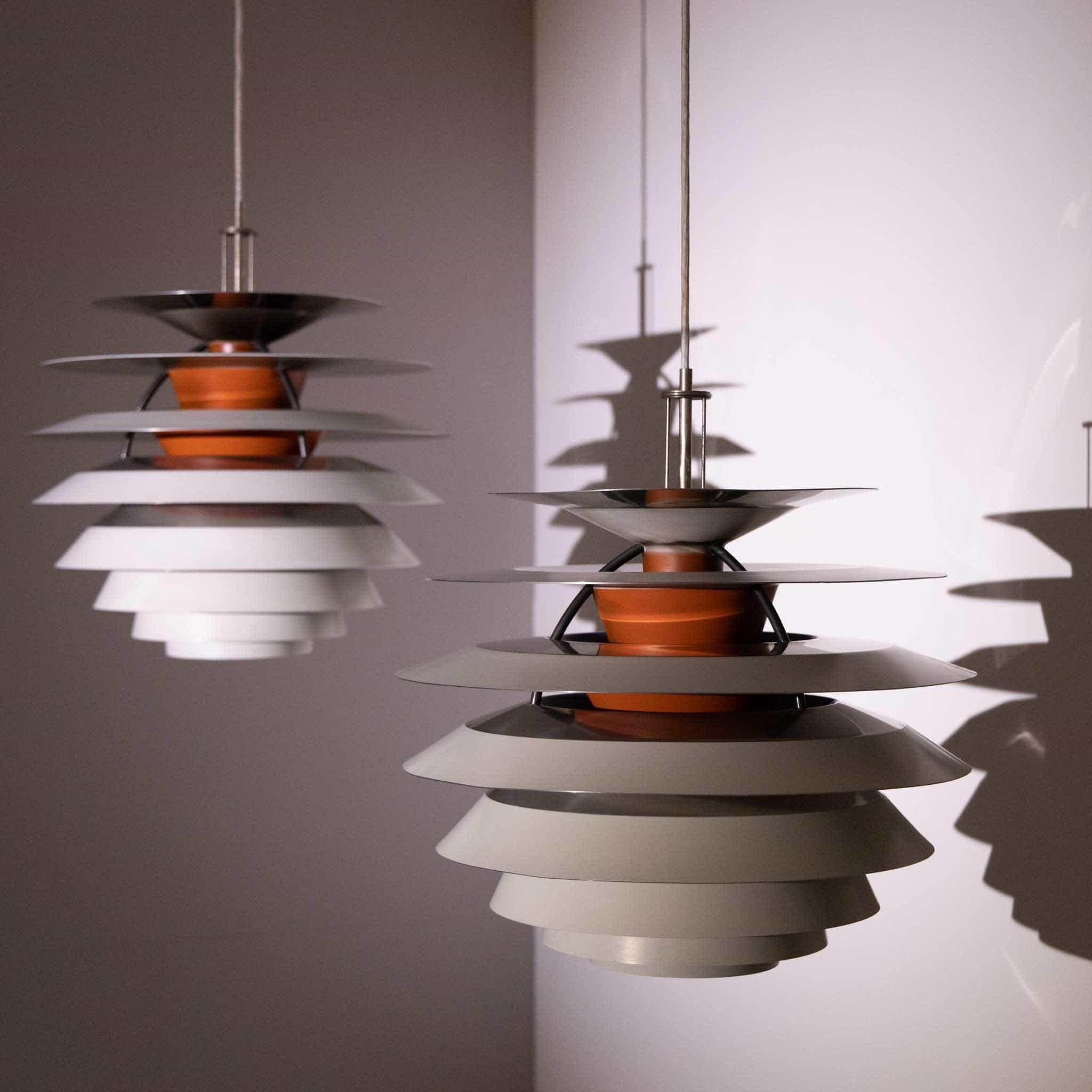Pair of pendant lights designed by Poul Henningsen for Louis Poulsen in the 1960s. This model “Kontrast,” is made of ten aluminum shades with three steel supports and a movable light bulb. 