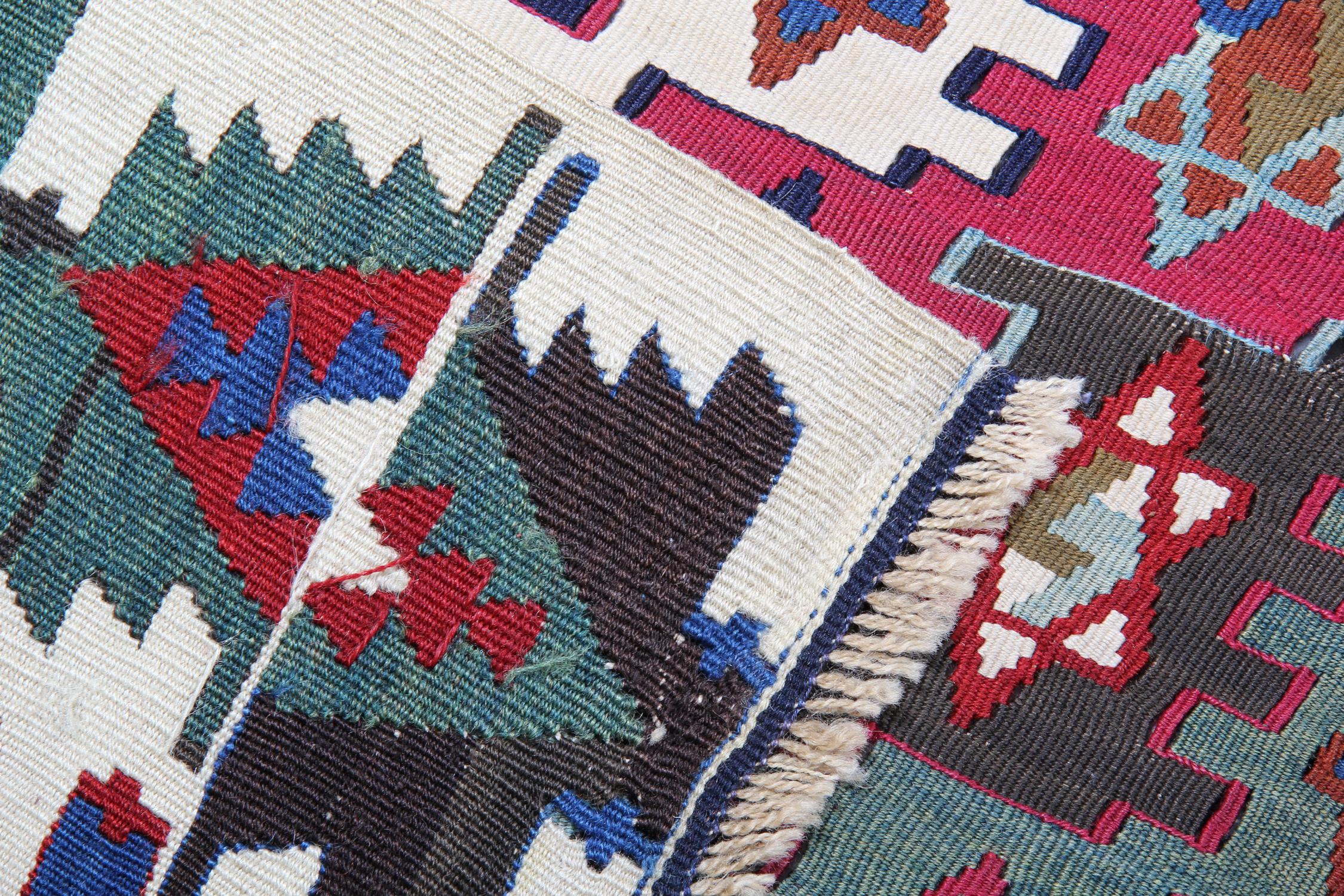 Questo antico tappeto Kilim di Konya, risalente agli anni '30, è uno straordinario esempio di tessitura tribale tradizionale, che mostra audaci motivi geometrici, colori vivaci e il carattere inconfondibile degli autentici tappeti turchi fatti a