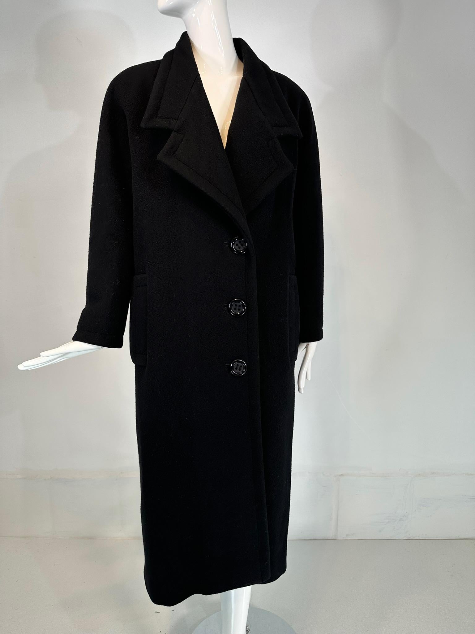 Koos Van Den Akker 1980s black wool coat with colourful abstract printed streamer appliques at the back. Winter weight wool coat with notched lapels at the collar, the coat closes at the front with three chunky shiny round black buttons. There are 2