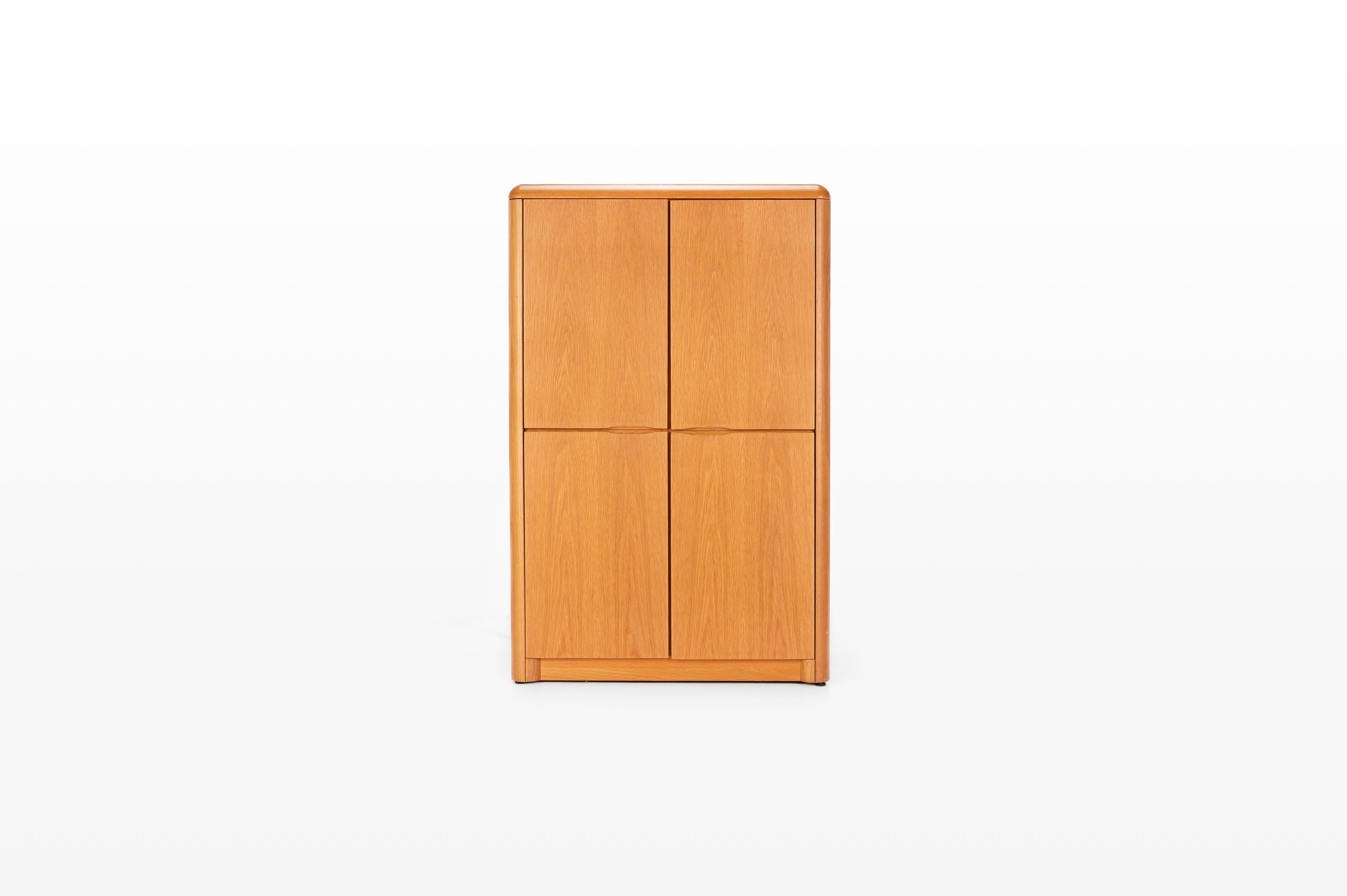 Mueble bar vintage belga de roble con barniz natural, fabricado por Van den Berghe-Pauvers. Este mueble bar tiene cuatro puertas batientes, cinco estantes de madera y dos estantes de cristal. También tiene una zona de bar con iluminación. Una