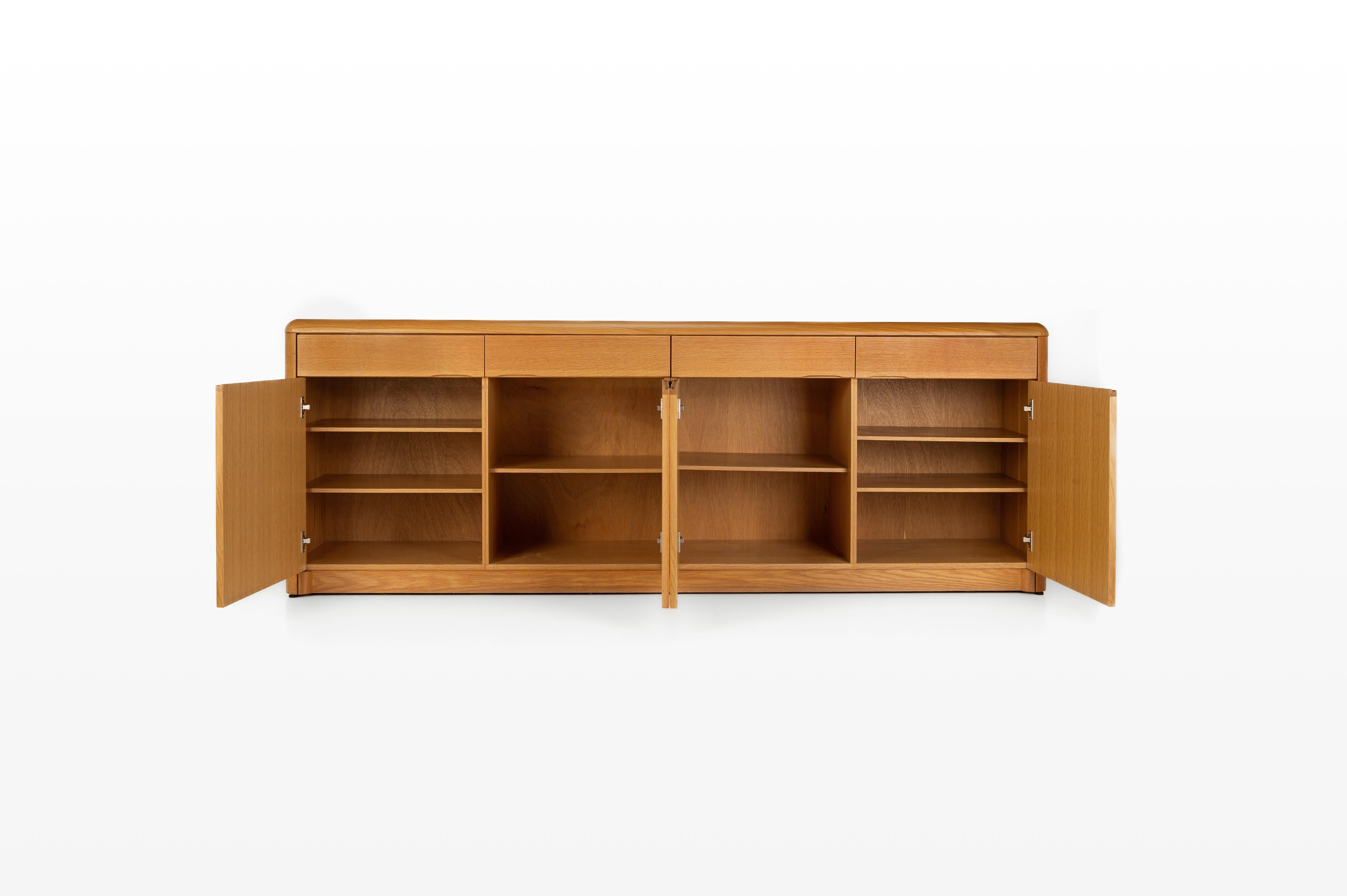 Buffet vintage belge en chêne avec vernis naturel, produit par Van DEN Pauvers comme modèle 'Kopenhagen'. Ce buffet comporte quatre portes à charnières, six étagères en bois et quatre tiroirs. Il est encore en très bon état. La preuve d'achat