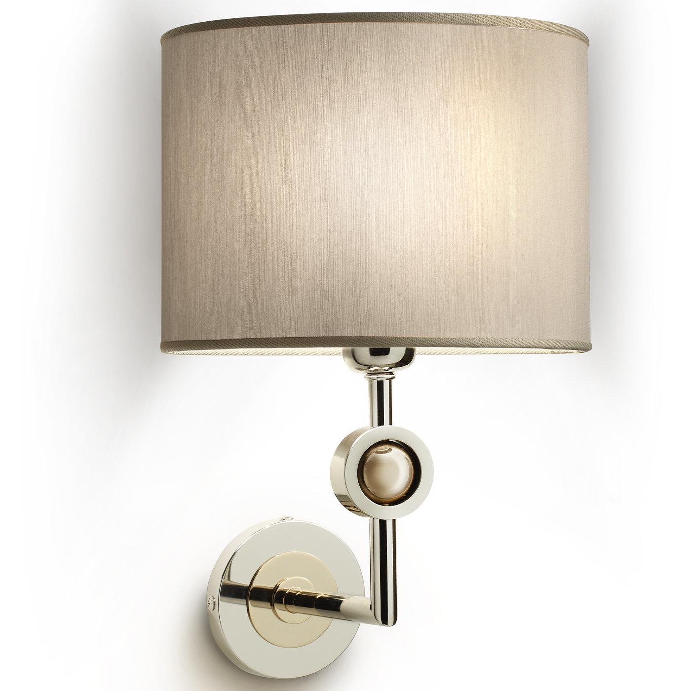 Flaunting an elegant brass structure finished in glossy nickel, this precious sconce is simultaneously illuminating and luminous. The right-angled arm connected to the circular wall mount is enlivened with a front finial harmonizing with the