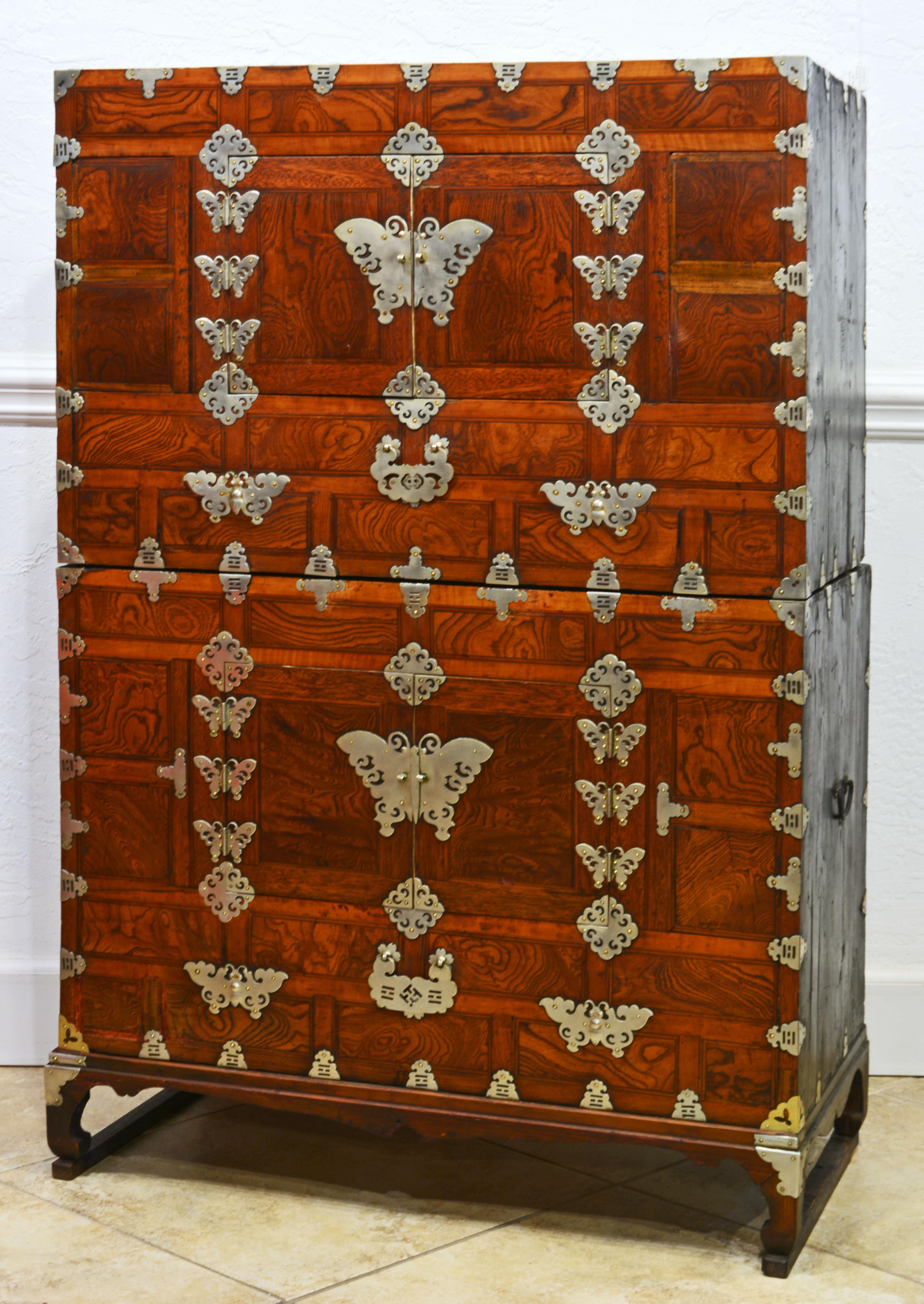 Both the upper and the lower part have multiple decorative white brass mounts. Each features two doors mounted with butterfly hinges and butterfly center-mount. The doors open up to paper lined interiors.