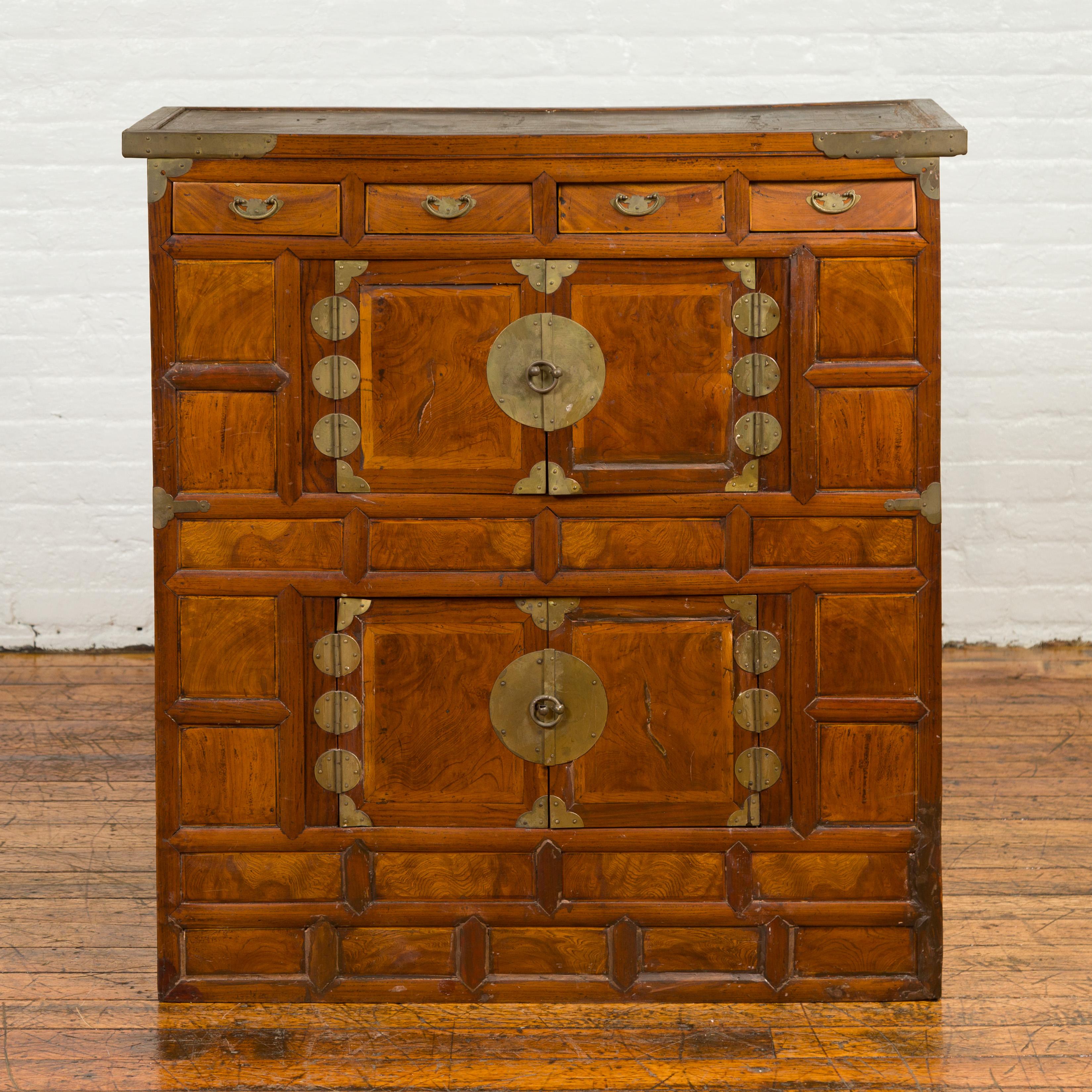 A Korean wooden cabinet from the 19th century, with four drawers, two sets of double doors and brass hardware. Born in Korea during the 19th century, this cabinet features a rectangular top with slightly recessed central panel, sitting above a