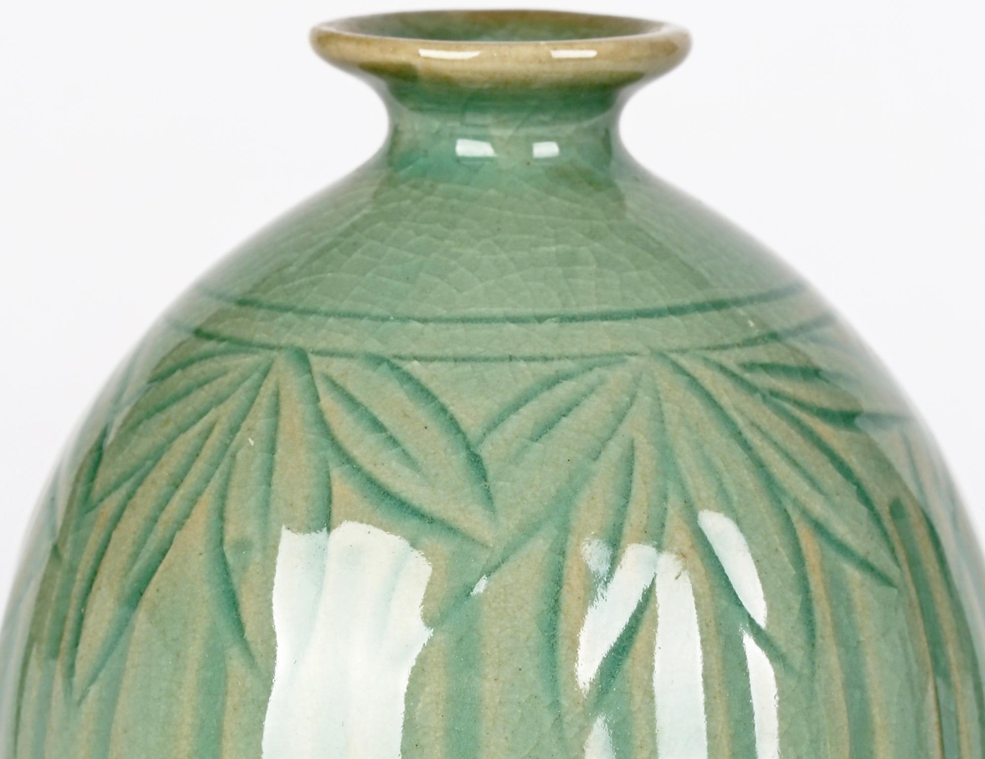 A very fine quality vintage Korean attributed green celadon glazed bamboo design porcelain vase dating from early to mid 20th century. The vase stands on a narrow round unglazed foot with a slightly recessed and glazed base and is of tall bulbous