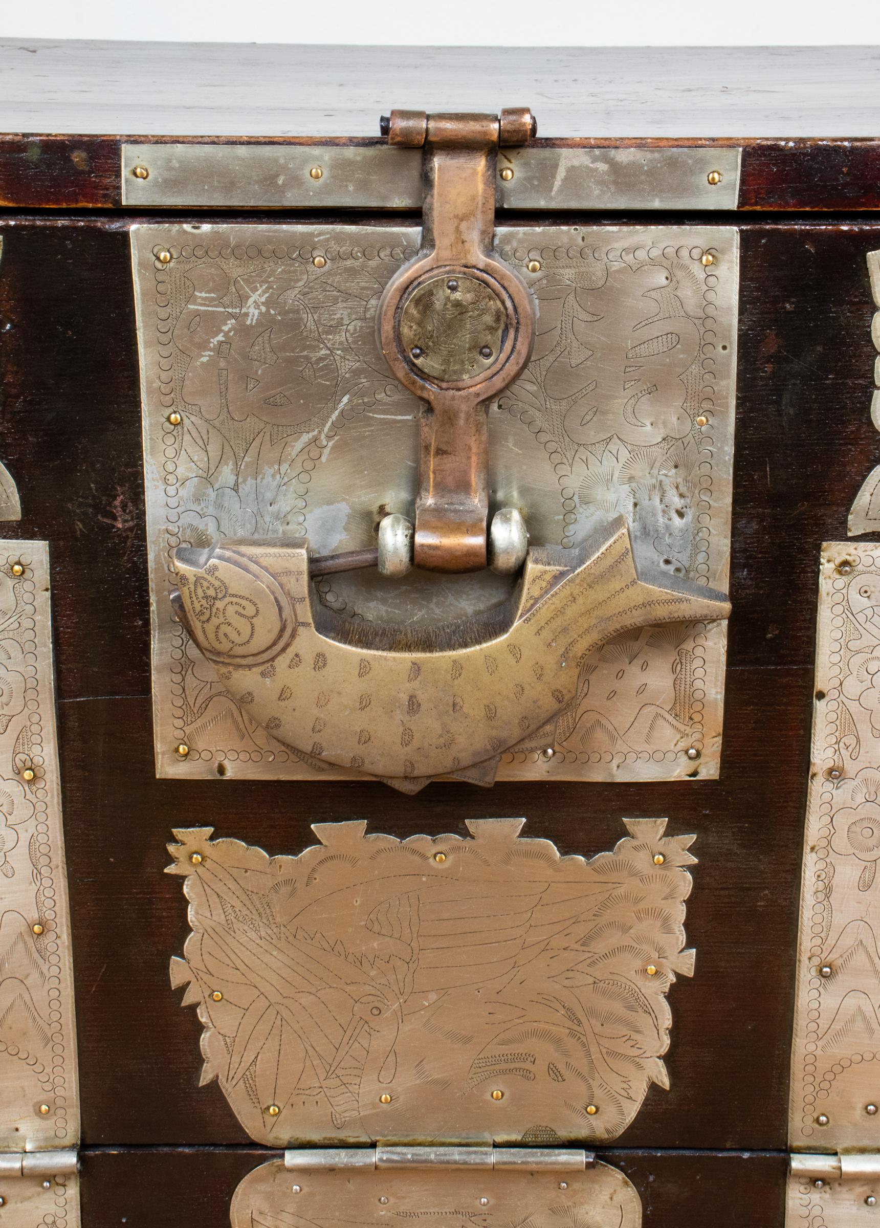 Korean Bandaji hardwood storage tansu chest, 19th century, with drop-front panel with a large central ring lock in the form of a stylized bird lock, overall with chased hardware having incised animal and character designs, with spacious storage