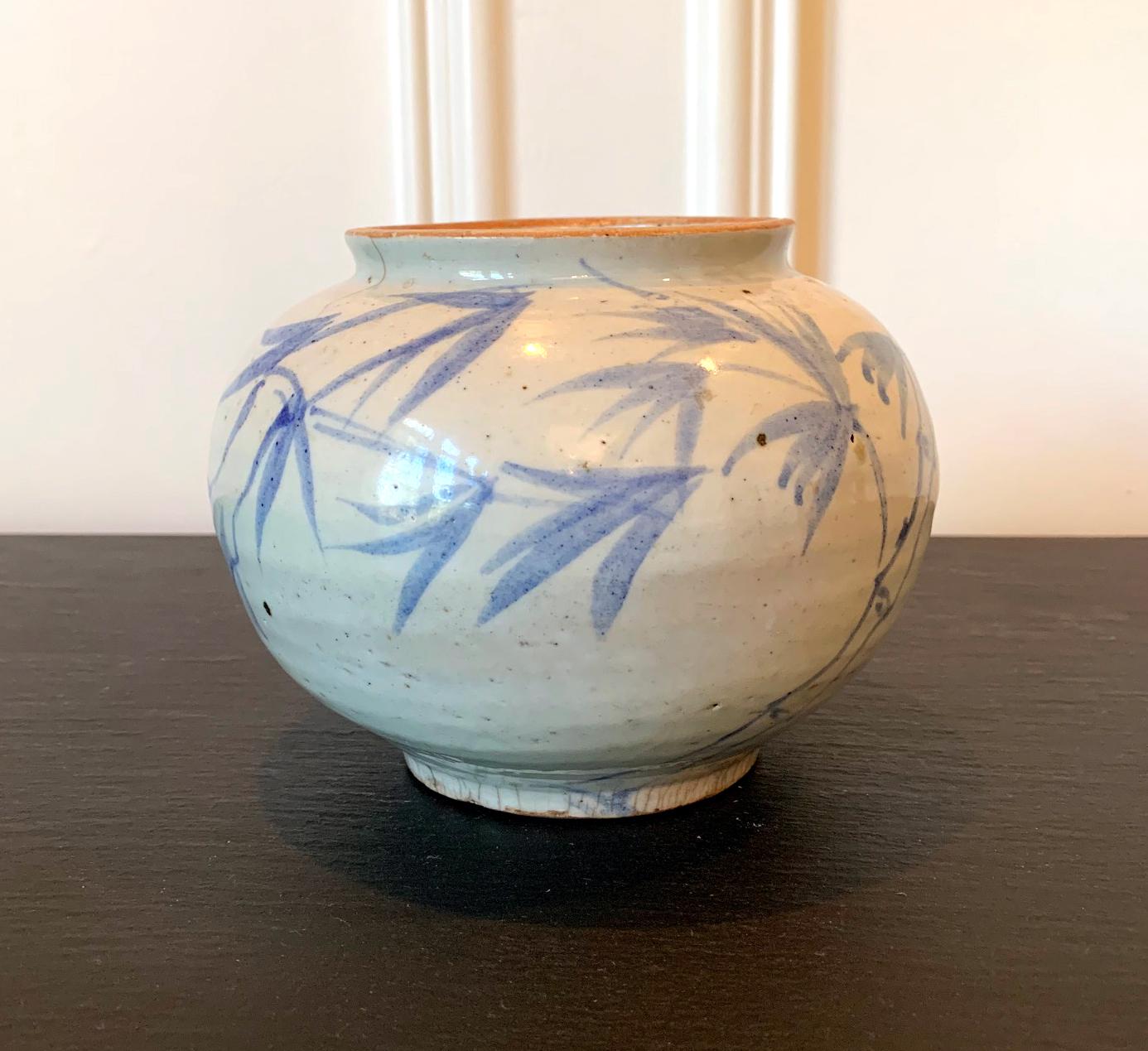 This Korean ceramic storage jar is dated to late Joseon or Yi dynasty, circa 19th century. It has a Classic rounded form with a short mouth lip and base ring, slightly irregular from the potter's wheel, yet it presents a quiet majestic energy. Under