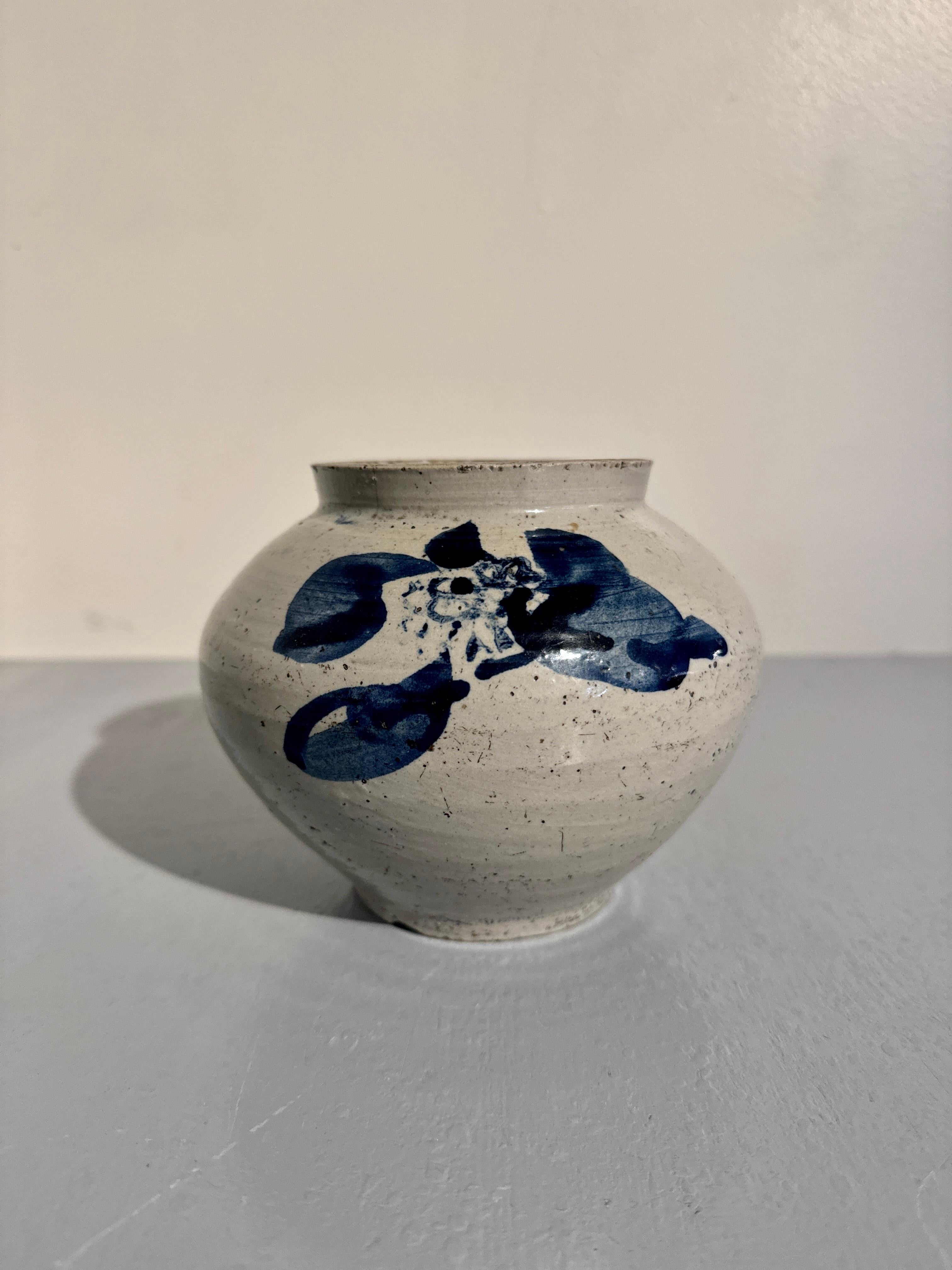 A darling and attractive Korean blu and white porcelain small jar, very late Joseon Dynasty, circa 1895, Korea.

The small jar of squat form, with a slightly compressed globular body with short neck and wide mouth, all set upon a short foot ring,