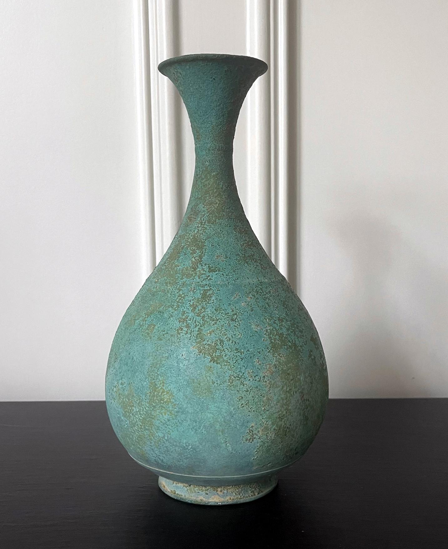 An antique Korean bronze bottle of bulbous pear form with a long neck and flared open mouth from Goryeo Dynasty (918 AD-1392 AD) circa 12-13th century It was thought that the type of bottle with such harmonious form and proportion was inspired from