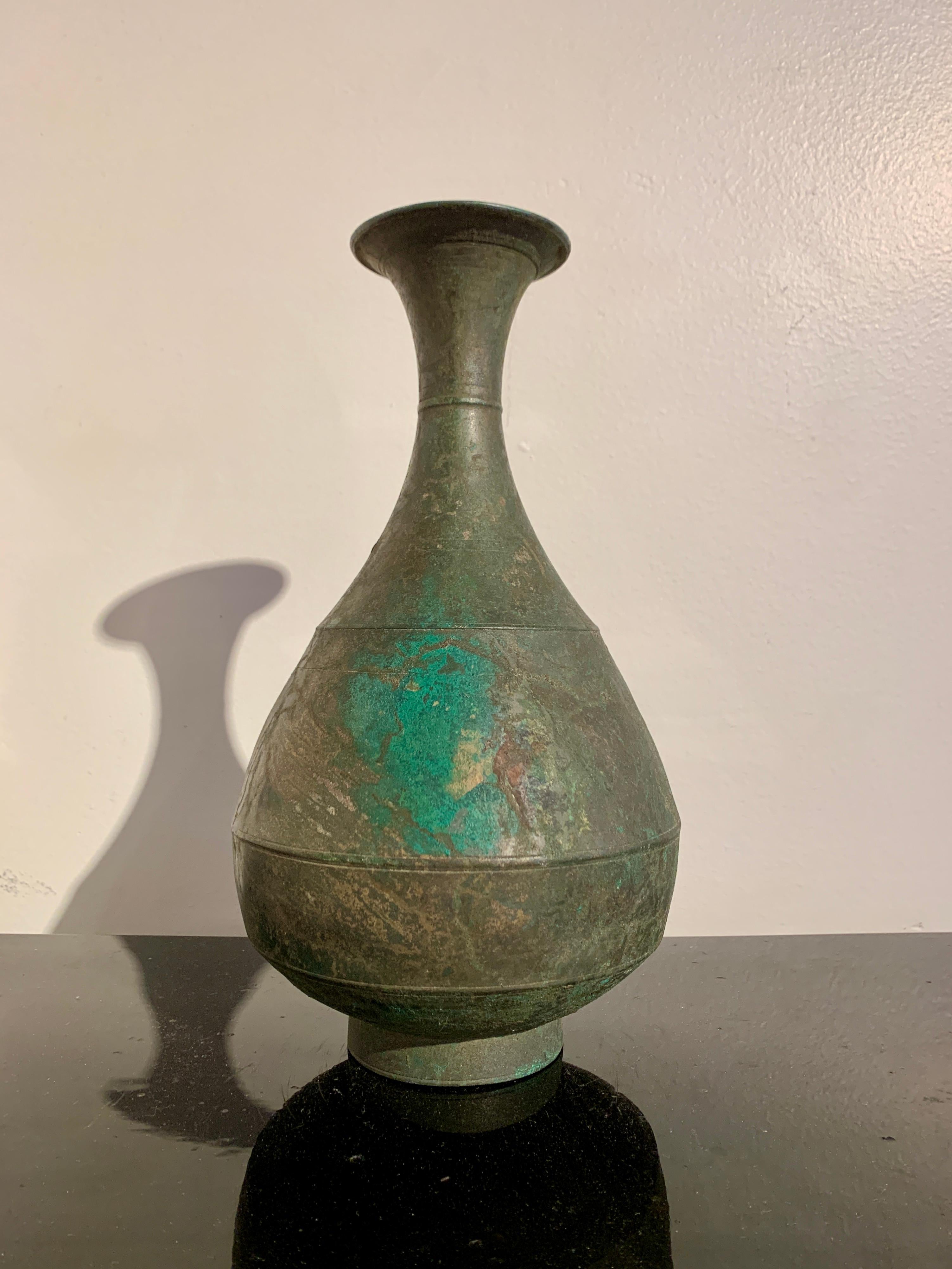 An attractive Korean Goryeo Dynasty bronze bottle vase with traces of gilding, 11th - 12th century, Korea.

The vase of typical form, with a short recessed foot supporting a pear shaped body, tall neck, and wide, everted mouth. The bronze with an