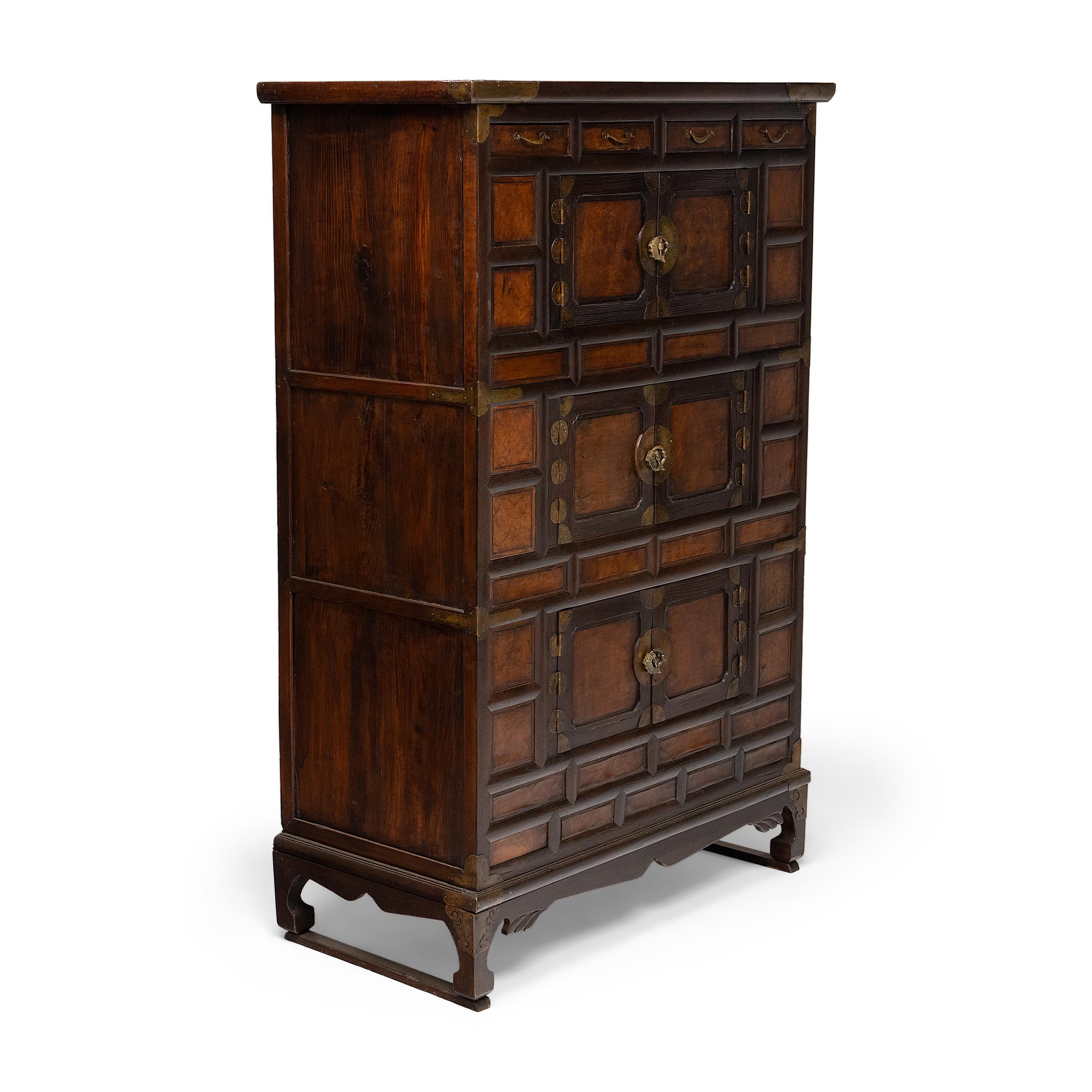 Ce meuble à plusieurs niveaux est un coffre à vêtements (jang) coréen du XIXe siècle utilisé pour ranger les vêtements pliés et les accessoires personnels. L'armoire est magnifiquement revêtue de panneaux de bois de ronce encastrés, incrustés de