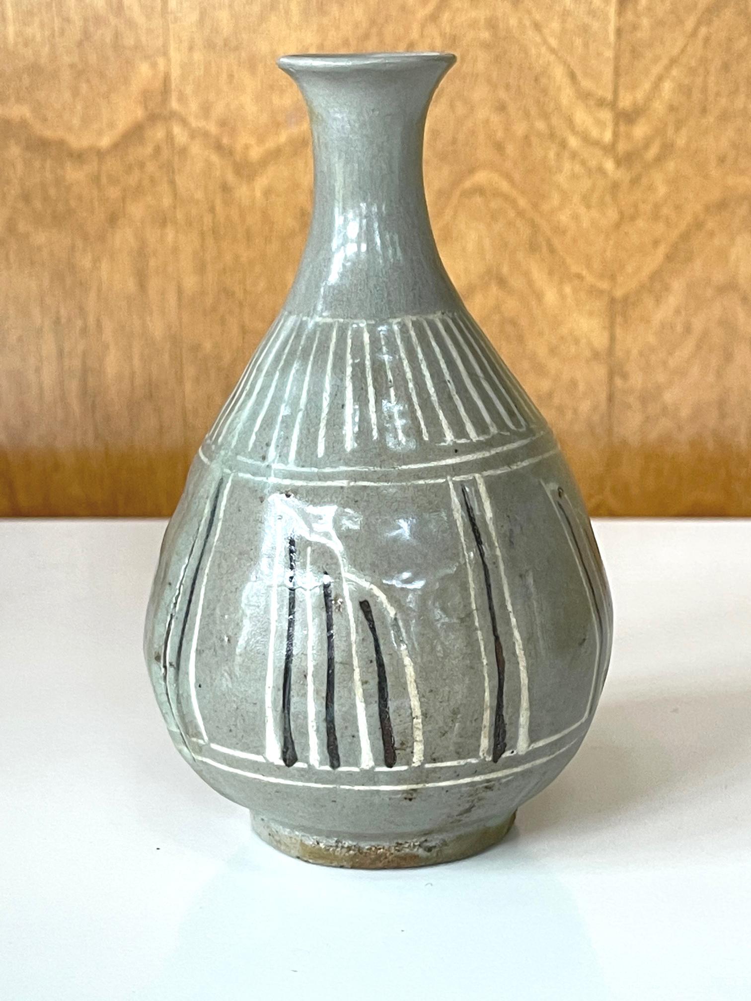 On offer is an antique Korean ceramic vase from the end of Goryeo to the beginning of Joseon period (circa 14-15th). The vase features celadon crackled glaze with underglaze inlay design in black and white. The vase was a transitional piece made
