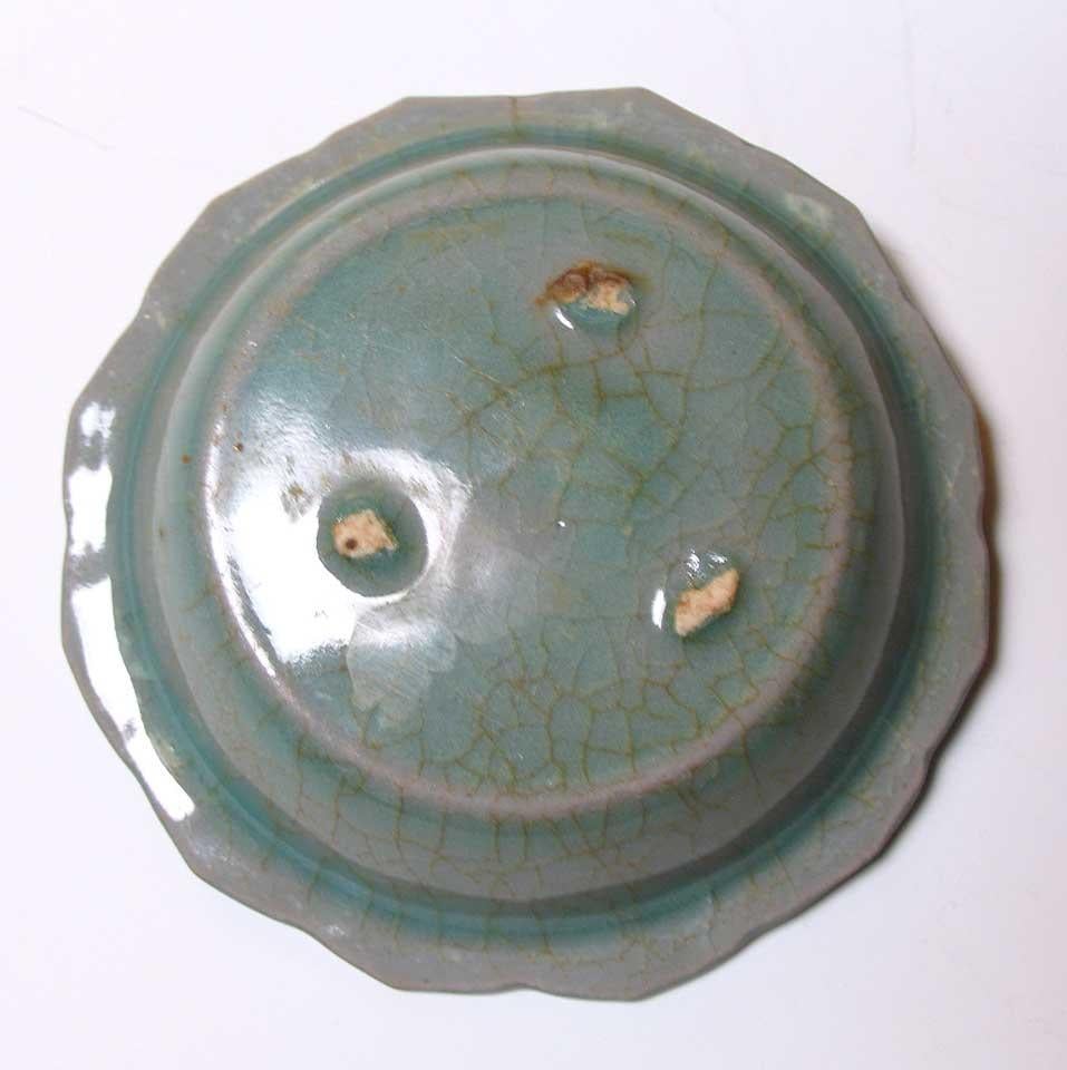 KG70006, Korean celadon small barbed rim dish with impressed ruyi head decoration on the interior and lotus petal sides terminating in a barbed rim, glazed overall in a thick translucent and crackled pale celadon glaze with three spur marks on the