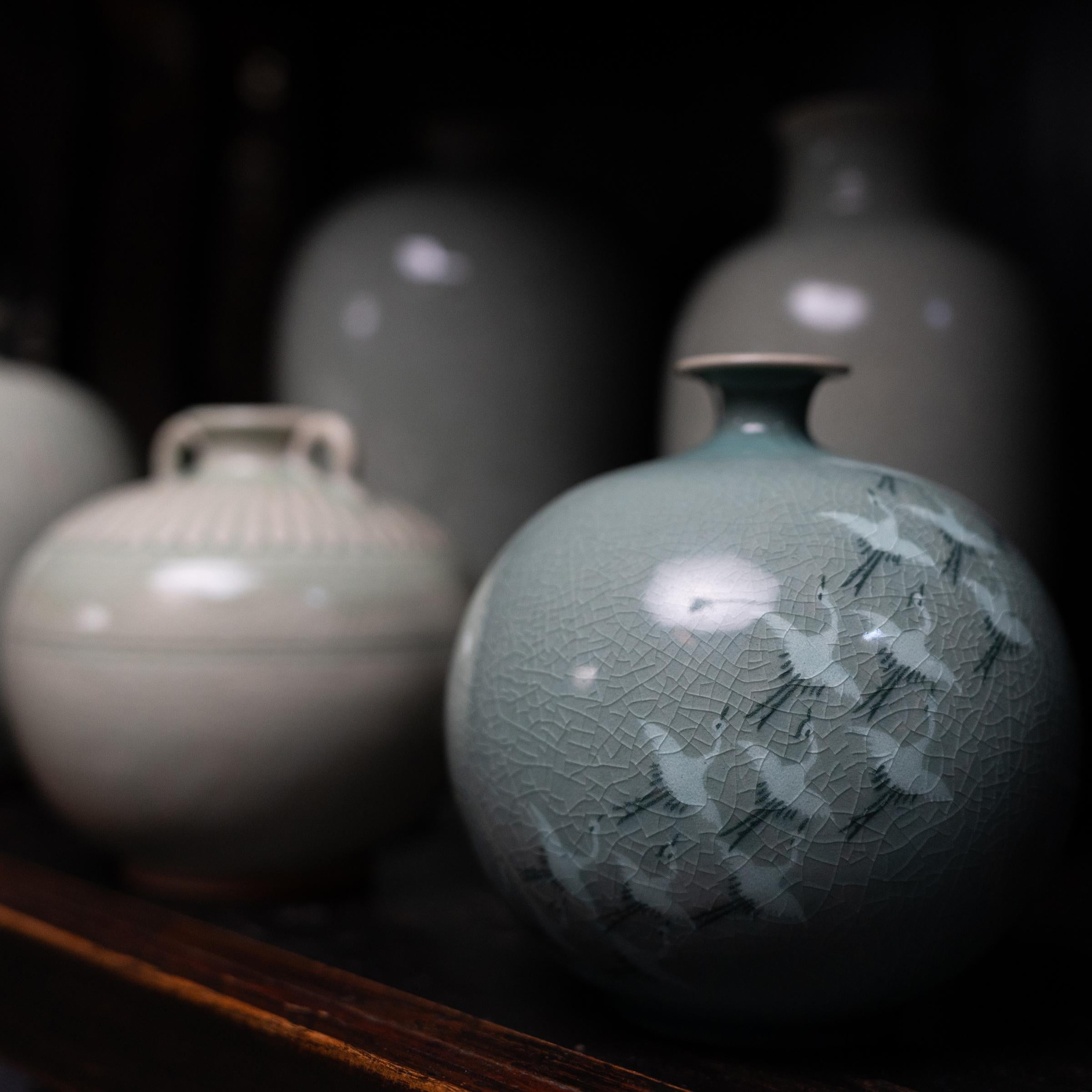 Korean celadon pottery, known as cheongja, was perfected during the Goryeo dynasty (918 to 1392), when Korean kilns began emulating the turquoise color of Chinese celadon wares of the Song dynasty. This vintage cheongja vase has a traditional