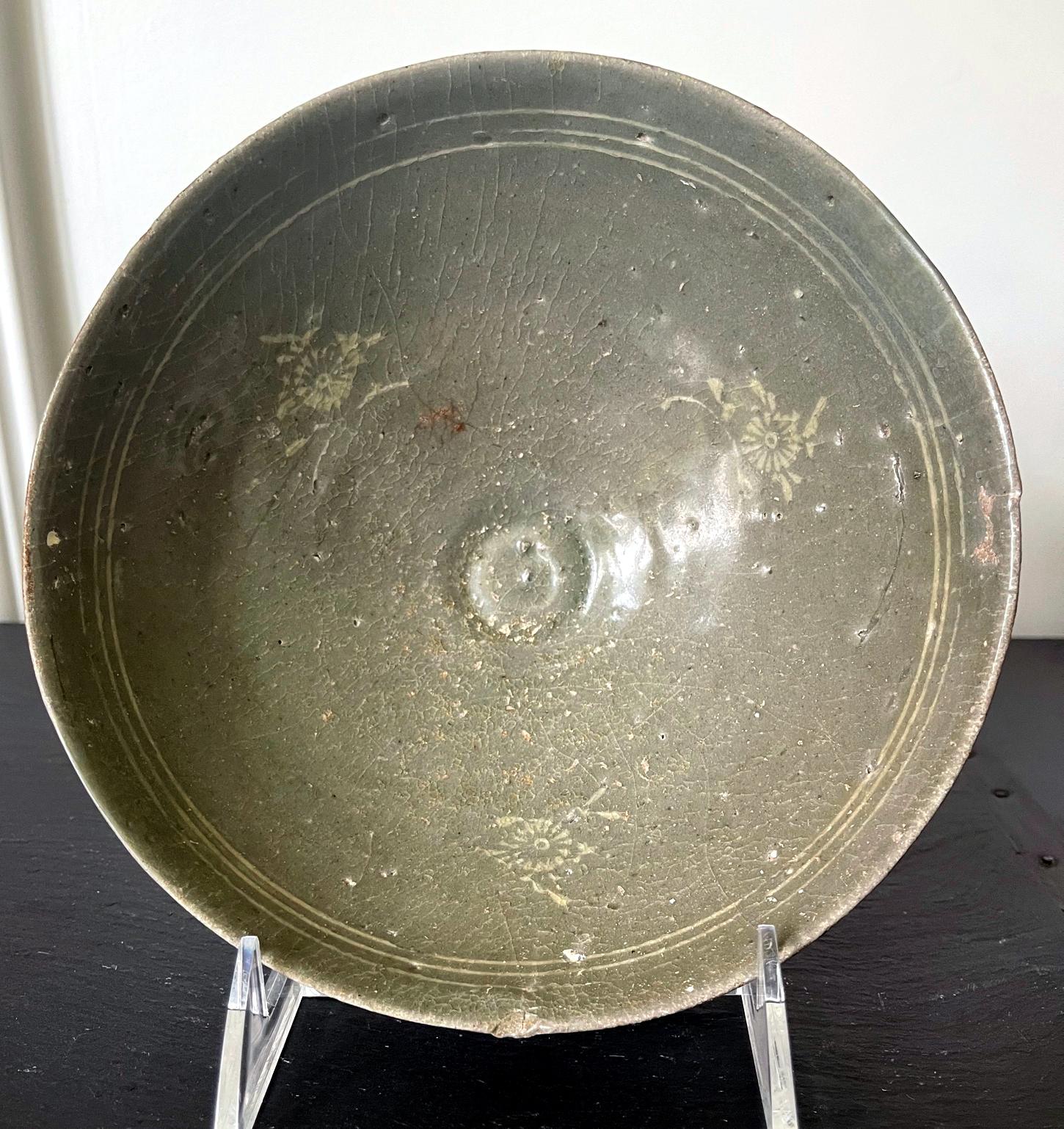 The celadon bowl on offer here was likely dated to the 14th century toward the end of Goryeo Dynasty, after the production quality reached its zenith during 11-12th century. The bowl was apparently wheel-thrown, slightly misshaped, and with a more