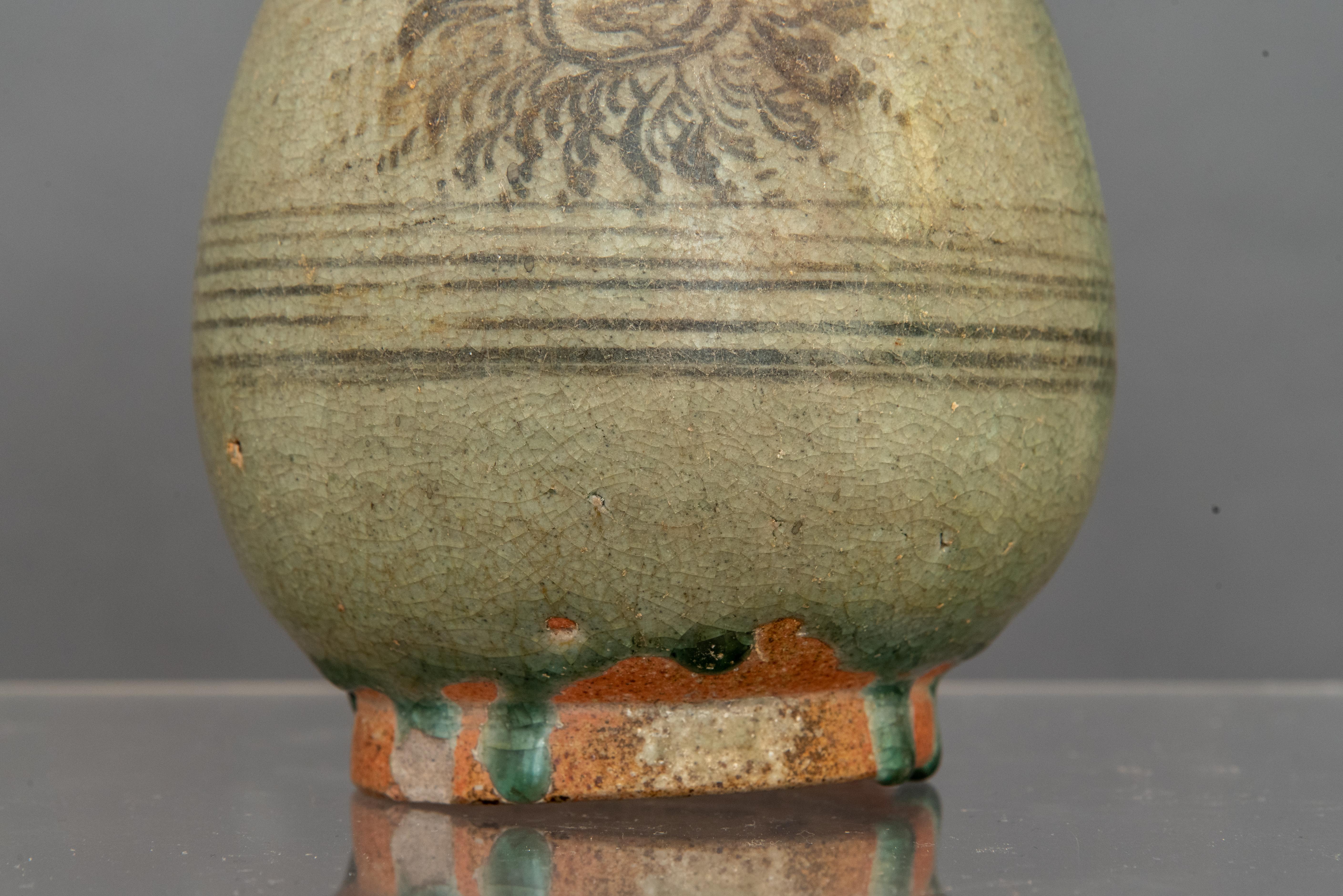 This is from Thailand and it is fifteenth century. Everything about it says so. The stoneware is terracotta colored  and there is a pontil mark on the bottom. Pontils were cylinders of dark clay used to hold pieces up off the floor in Thai kilns and
