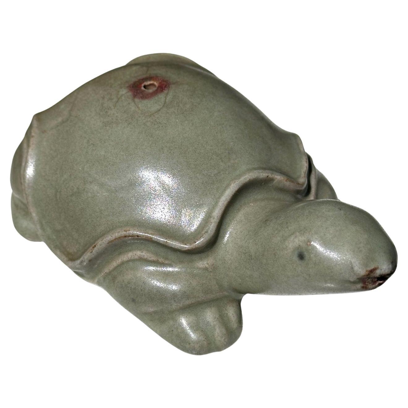 A Korean ceramic water dropper in the form of a turtle or tortoise from Goryeo Period circ 12-13th century. The realistically molded piece is covered in a mellow celadon glaze with subtle hexagon patterns incised on the tortoise shell. The refill