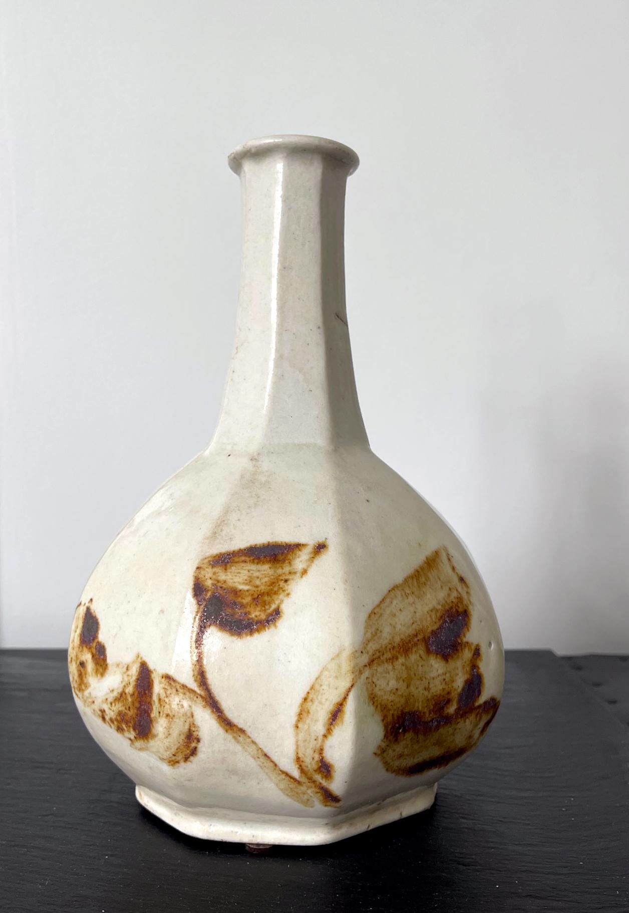 Eine koreanische Keramikflasche in achteckiger, facettierter Form mit kupferrotem Unterglasurdekor. Die robuste Flasche mit dem langen Hals und der relativ dicken Wandung diente zur Aufbewahrung von Spirituosen wie z. B. Wein und stammt aus der