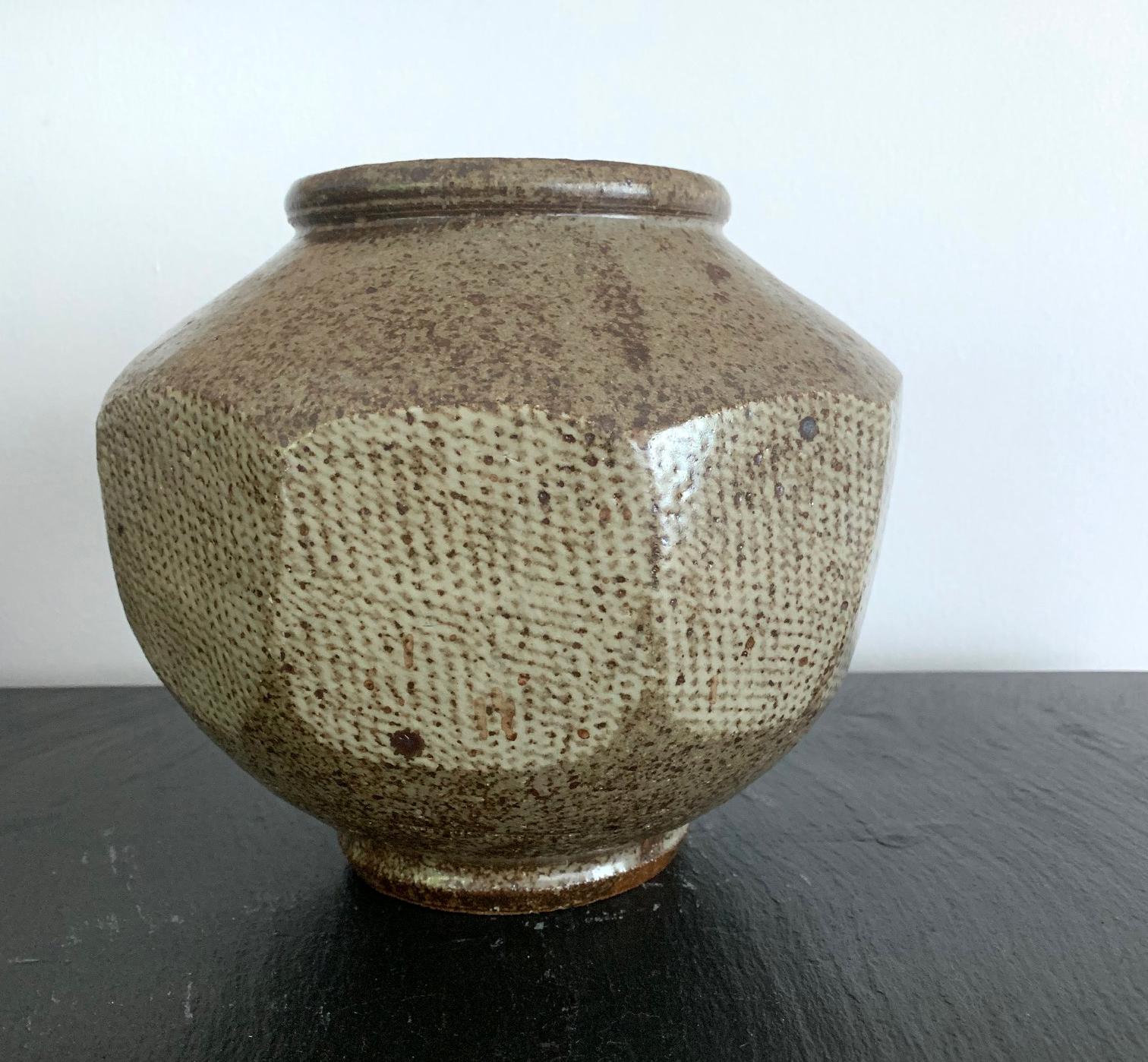 A handsome ceramic stoneware storage jar from Korean Joseon dynasty (1392-1897), circa 15th-16th century. The exterior surface of the pot was hand cut into nonagon planes, which were further decorated with underglaze white slip. The diamond patterns