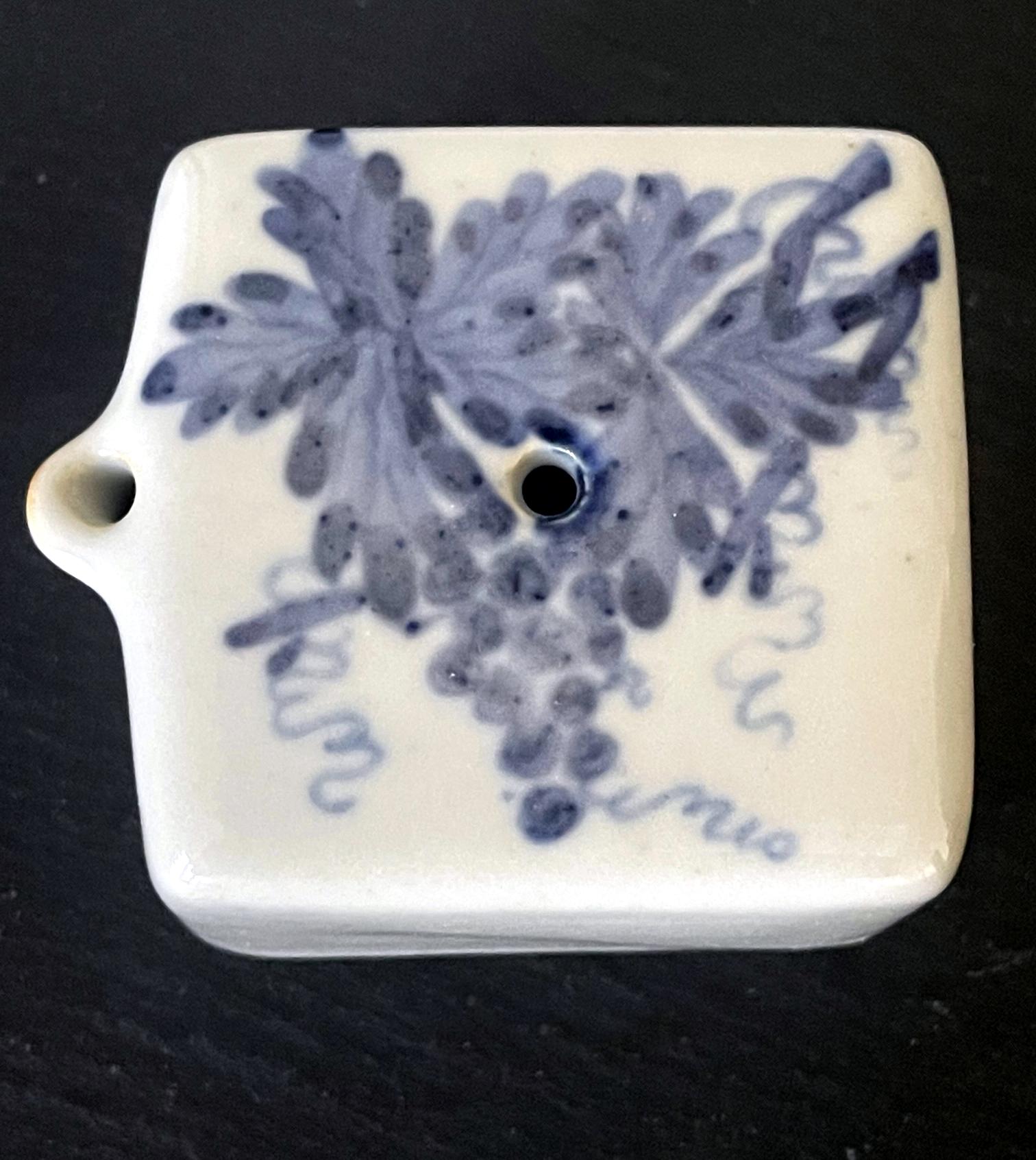 A small Korean ceramic water dropper in square form circa 19th century late Joseon Dynasty. It features an underglaze blue painting of a full cluster of grapes with vines and leaves on white background. A central small opening is for refill and a