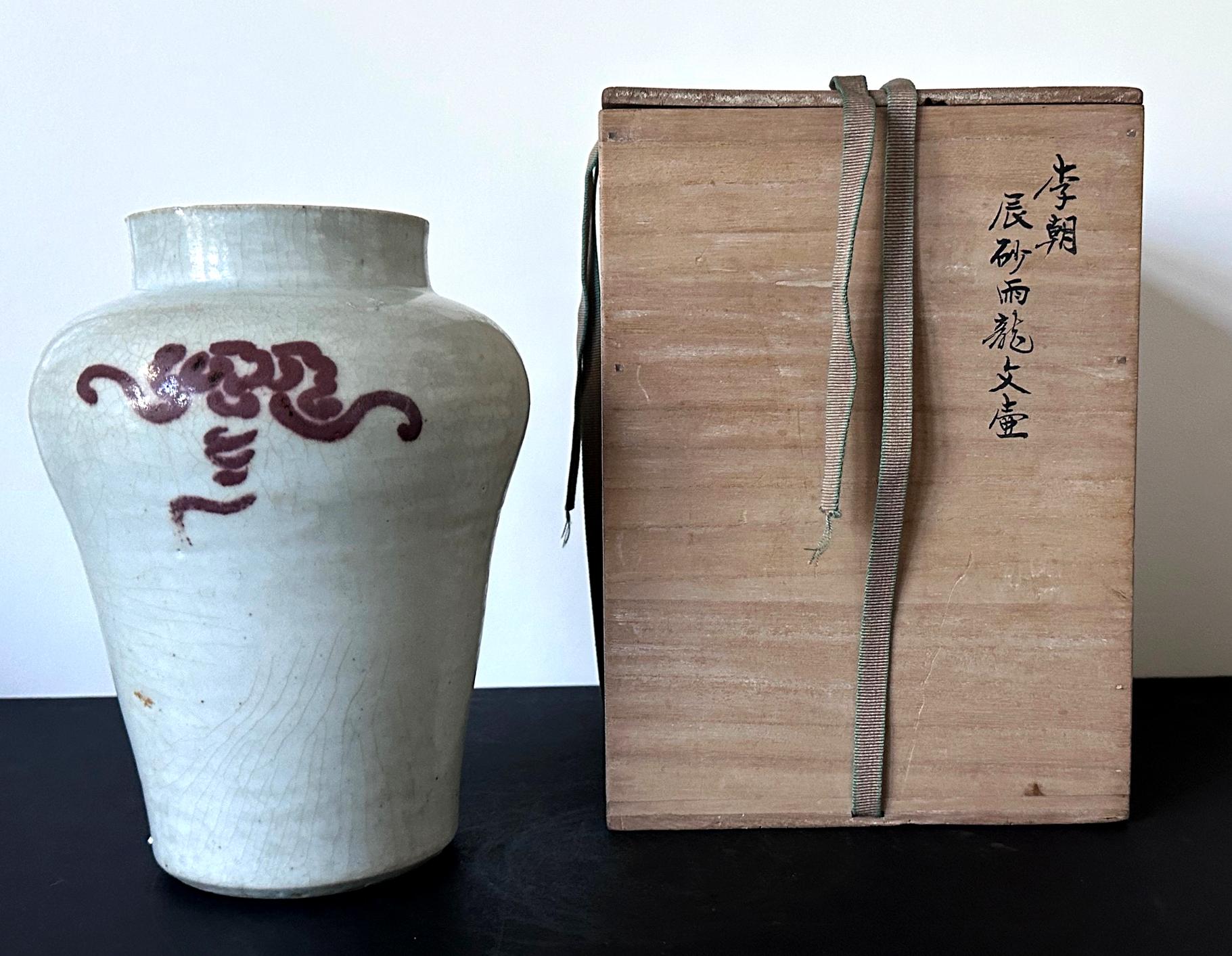 An antique Korean porcelain storage jar from Joseon Dynasty circa 18-19th century. The jar is of a typical form with swelled shoulder that tapers down toward the base. It features a short upward neck with a large opening. The surface is covered in a
