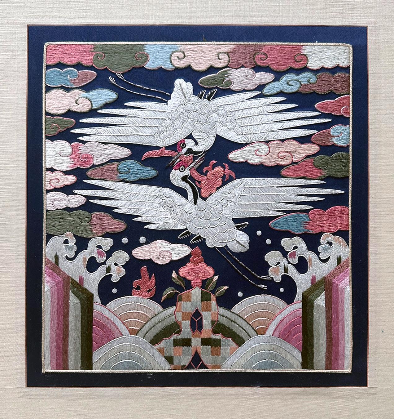 Distintivo di grado coreano finemente ricamato (Hyungbae in coreano) della dinastia Joseon, circa alla fine del XIX secolo. Il distintivo presenta un disegno di doppie gru volanti circondate da nuvole colorate di buon auspicio sopra le onde e le