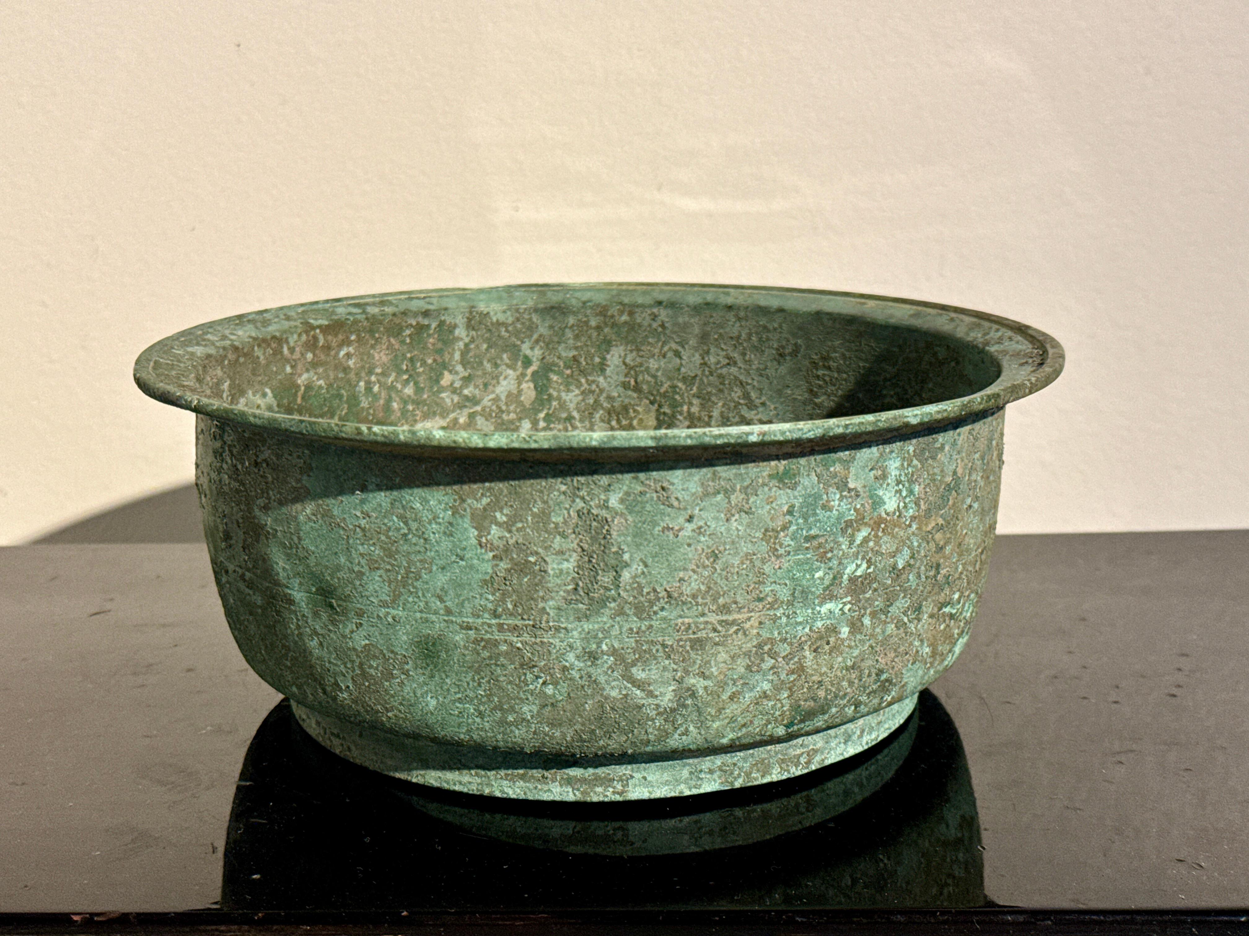 A sublime Korean bronze ritual basin with incredible patina, Goryeo Dynasty (918 to 1392 AD), 12th - 14th century, Korea. 

The Goryeo bronze basin of shallow bowl form, set on a short and wide ring foot, with straight walls, an everted mouth, and