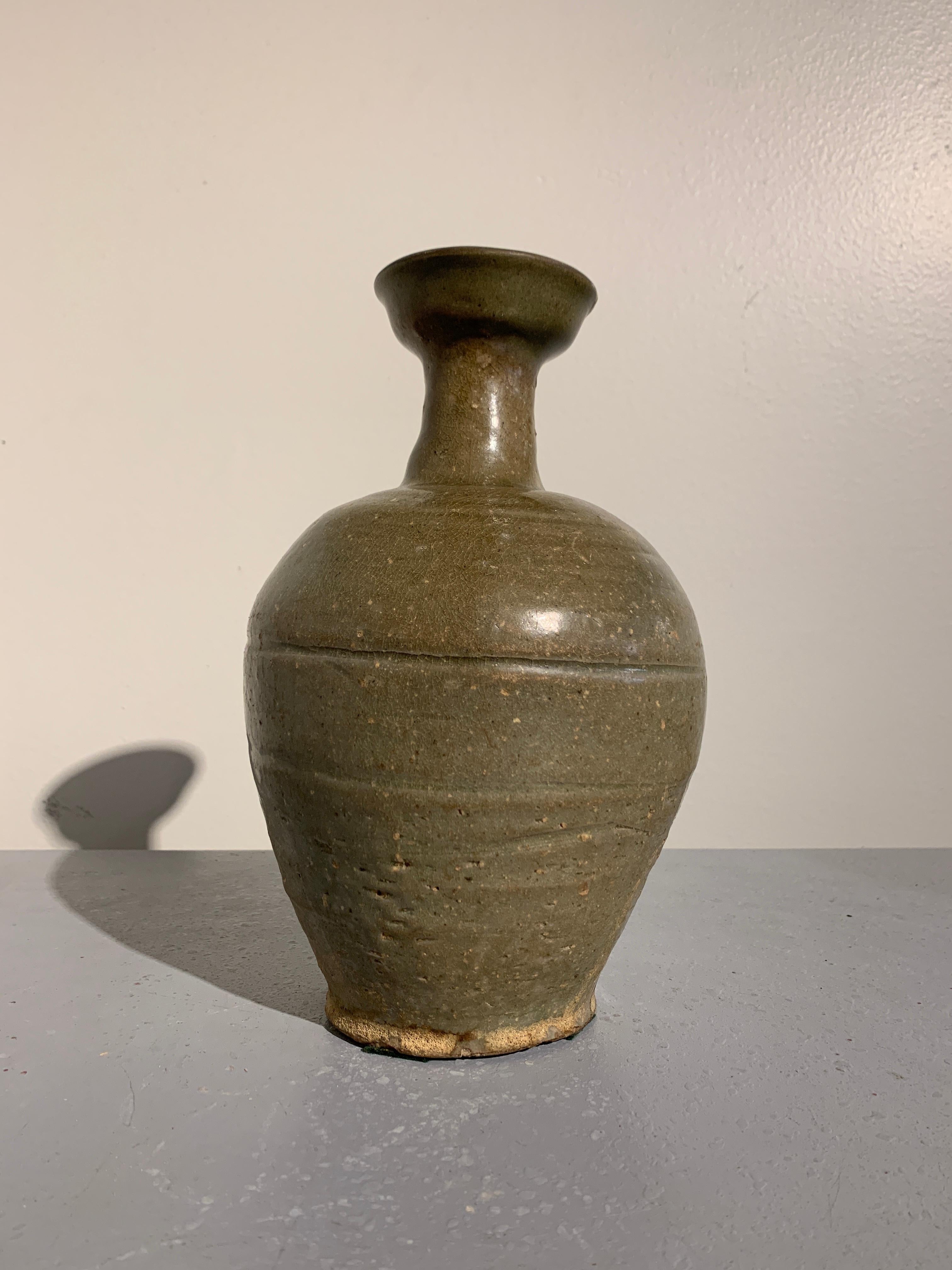A sublime Korean celadon glazed cup mouth bottle vase, Goryeo Dynasty, 12th century, Korea.

The elegant bottle vase, originally used to serve wine, features a gorgeous Goryeo celadon glaze. The body of baluster form, with a notable lean, plainly