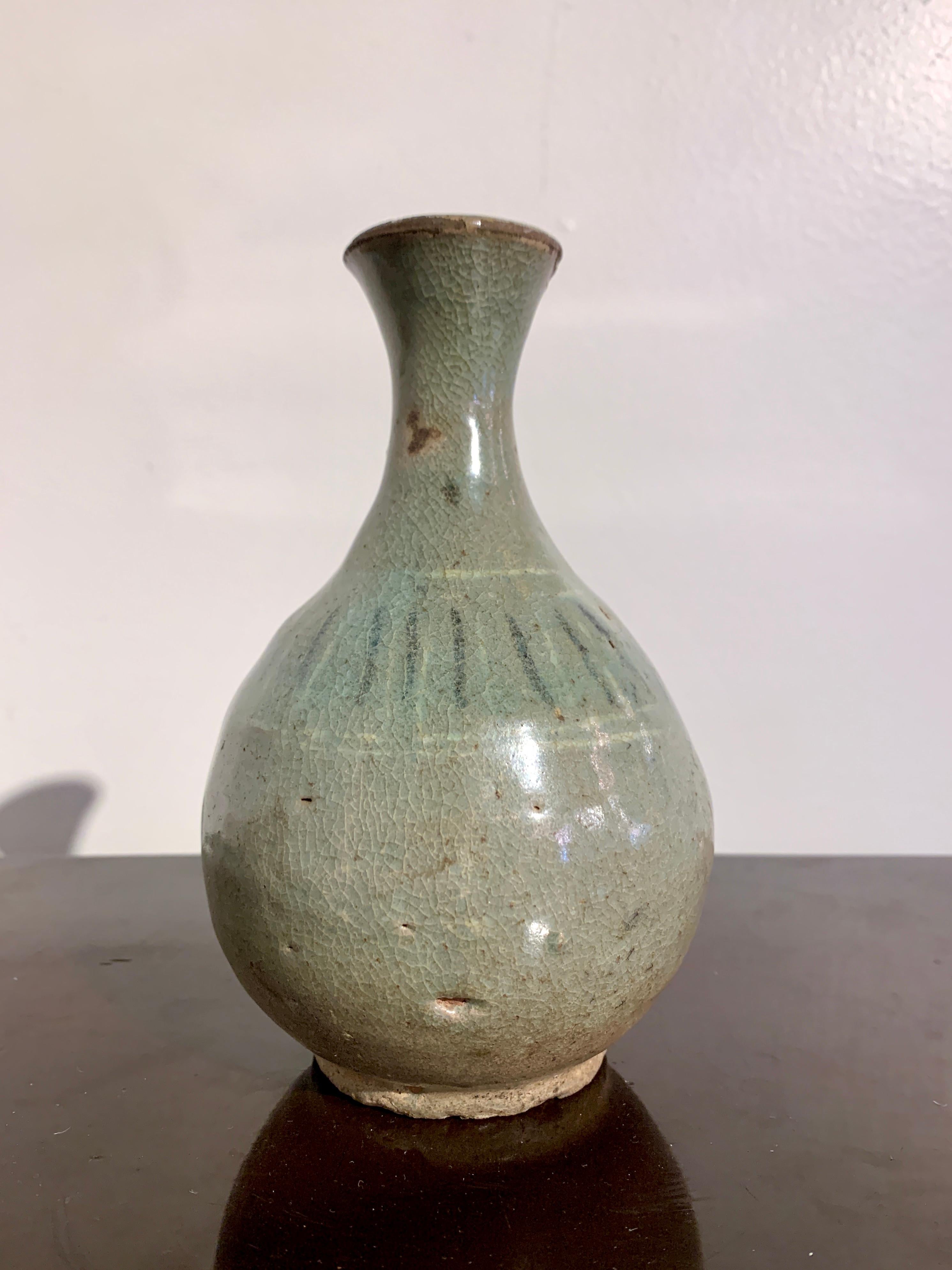 A lovely small Korean slip inlaid celadon glazed bottle vase, Goryeo Dynasty, 11th - 13th century, Korea.

The small vase heavily potted with a pear or teardrop shaped body, tall narrow neck, and everted mouth. The vase glazed all over in a blue