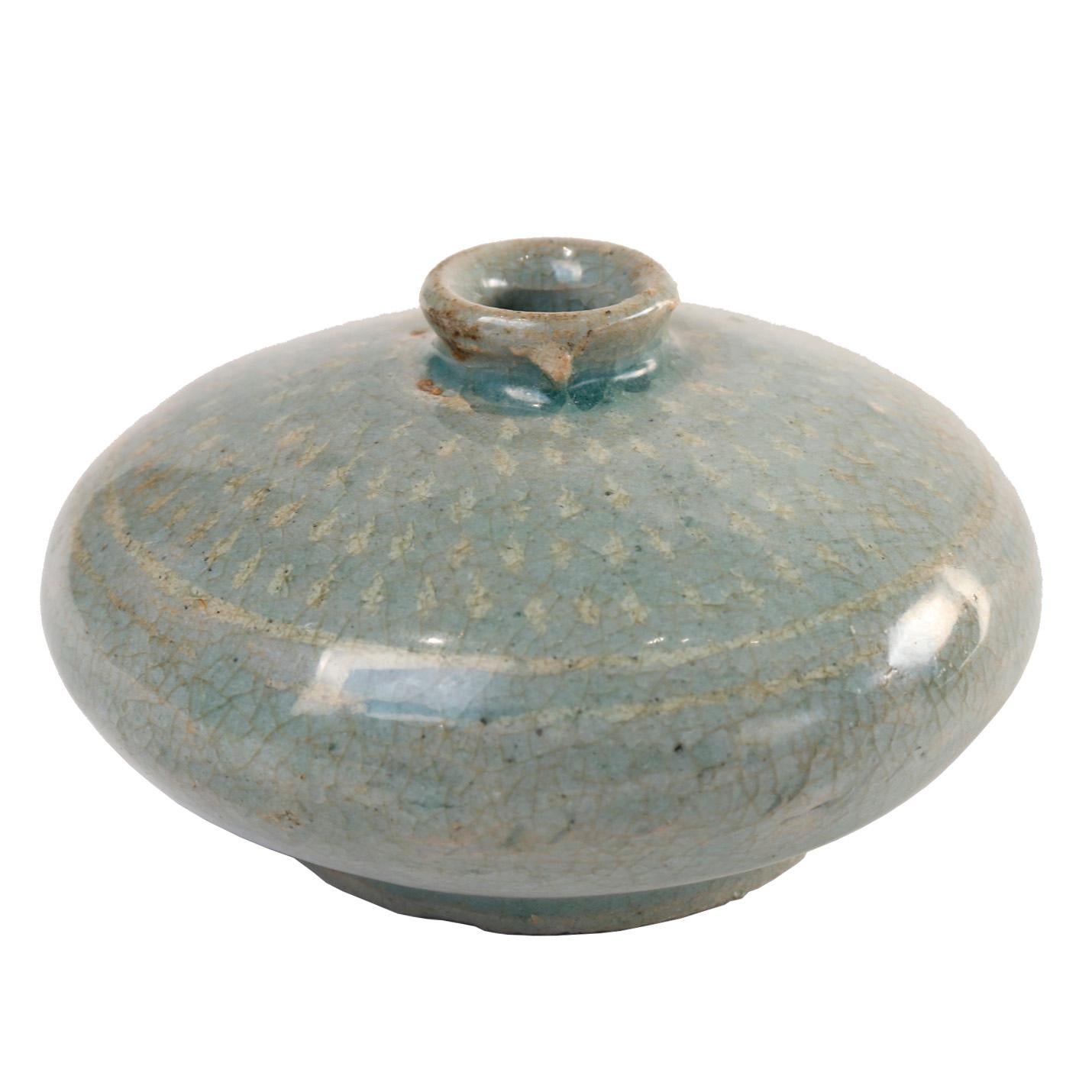  Bouteille d'huile en céladon incrusté, de forme globulaire trapue avec un col étroit et une embouchure présentant un motif de corde imprimé révélé dans l'engobe blanc, sur la base circulaire à pied épaulé avec des gravillons de four adhérant,