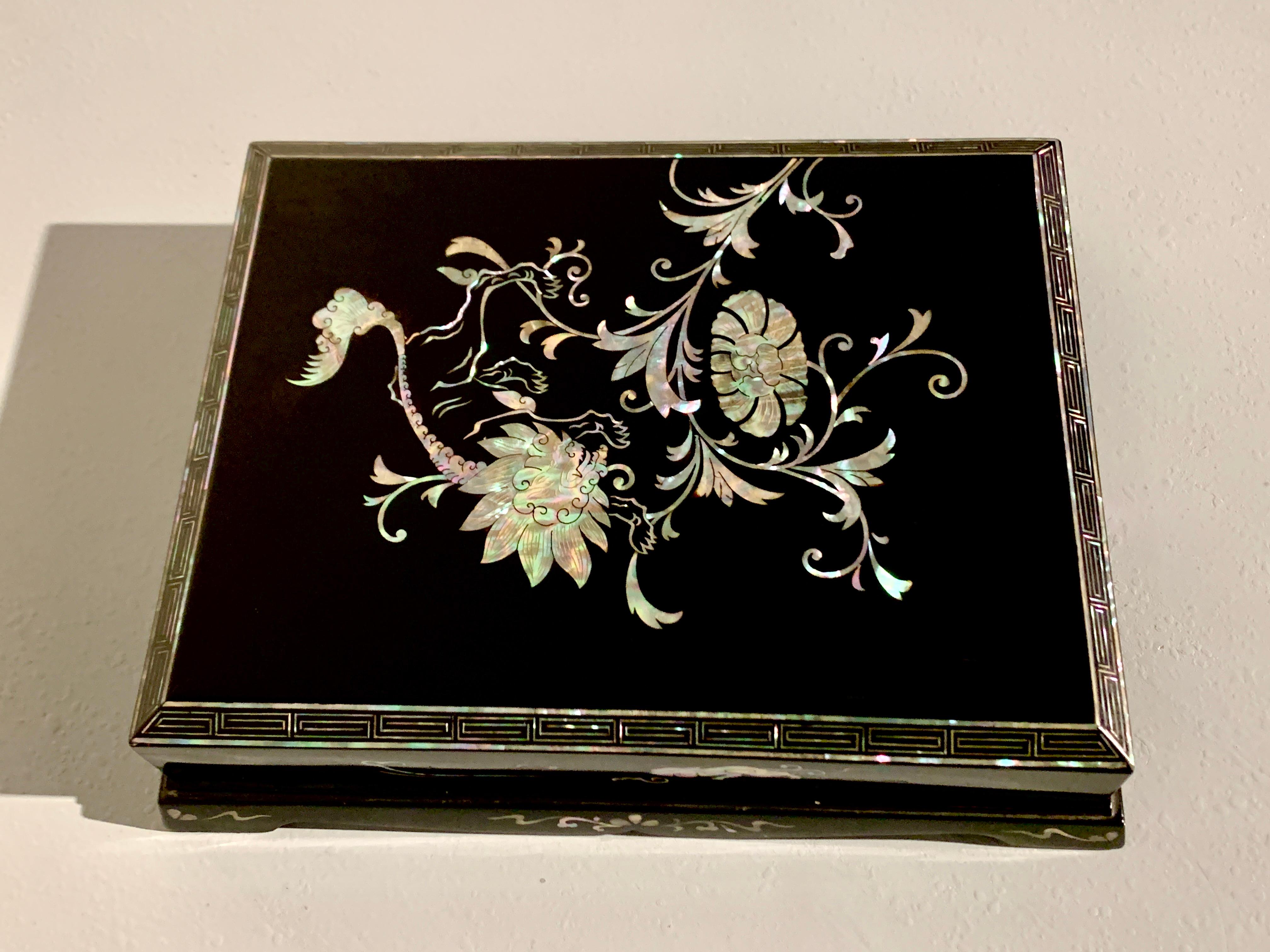 An elegant Korean black lacquer and mother of pearl inlay stationery box with lion and peony, circa 1930's, Korea.

The rectangular box and cover supported on a raised platform with shaped aprons all around. The cover of the box faceted design, with