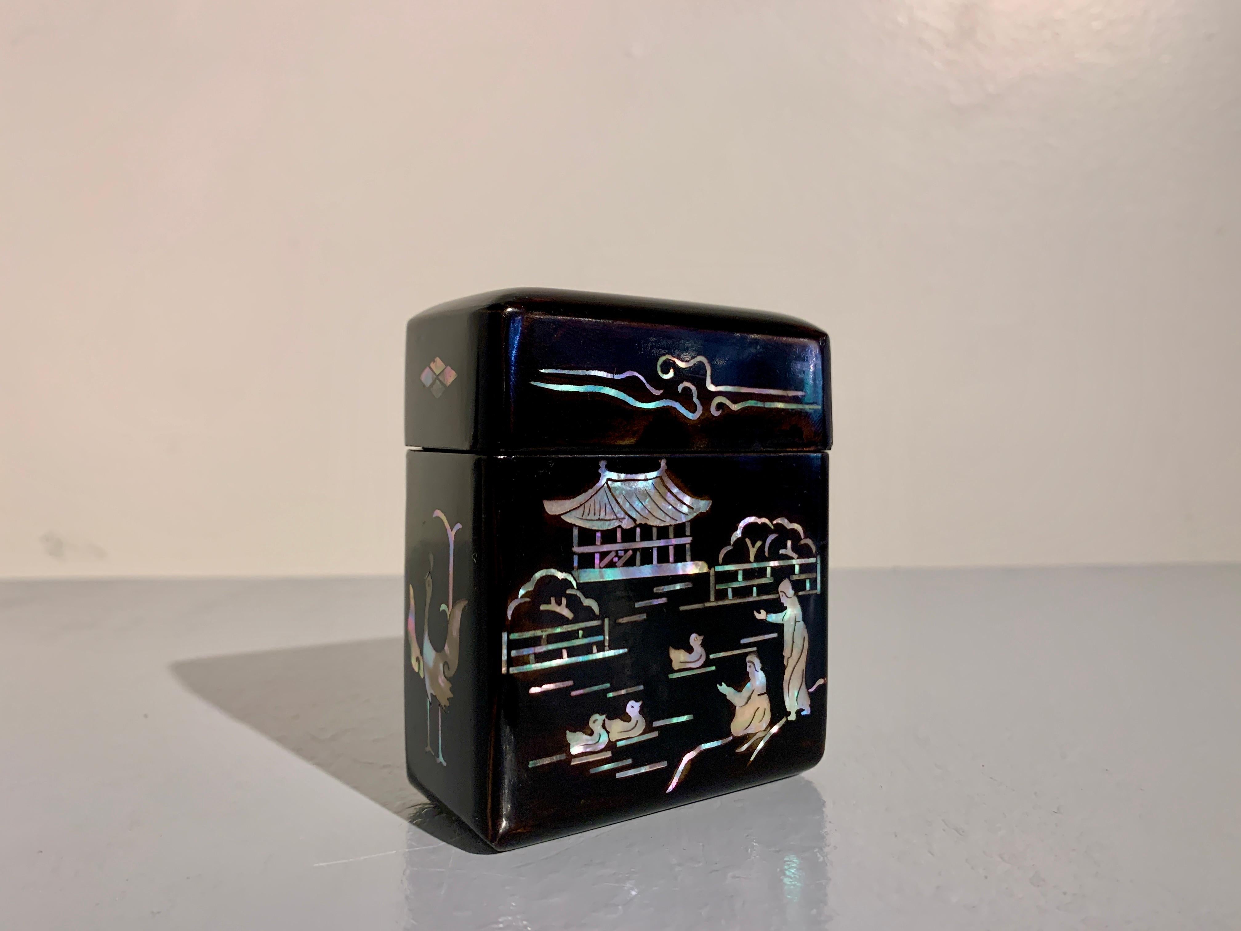 A small and charming Korean black lacquer and mother of pearl inlaid cigarette box, 1930's, Korea.

The small vertical lidded box, crafted of black lacquer with mother of pearl inlaid designs, with a vermillion red lacquered interior, originally
