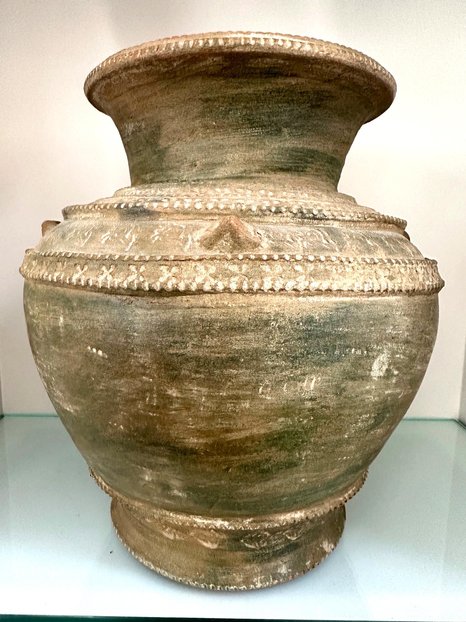 A terracotta pottery funerary urn with lid from Korea Unified Silla Period, circa 9th century. The jar was in a classic globular form with raised shoulder. Although the surface was unglazed, the jar features decoration with the stamped floral