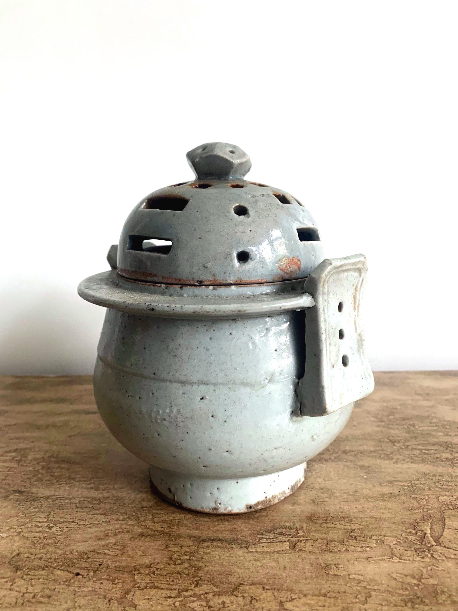 An antique Korean ritual incense burner circa 19th century, late Joseon dynasty. It was made in Bunwon Kiln in Gwangju, Gyeonggi Do, near Seoul. The ceramic container has a thickly body with white bluish celadon glaze. It is of an archaic Chinese