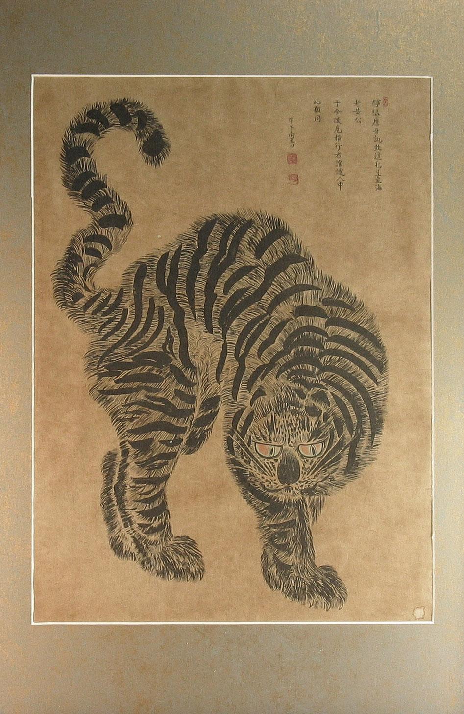 A Korean scroll of prowling tiger
20th century.

Size, 17 1/4 x 12 1/2in. (43.8 x 31.7 cm.)
Framed, 24 3/8 x 17 1/2 in. (62 x 44.5 cm.)

Painted in ink on buff paper of a glaring tiger with its tail flicked over its back, based on a painting