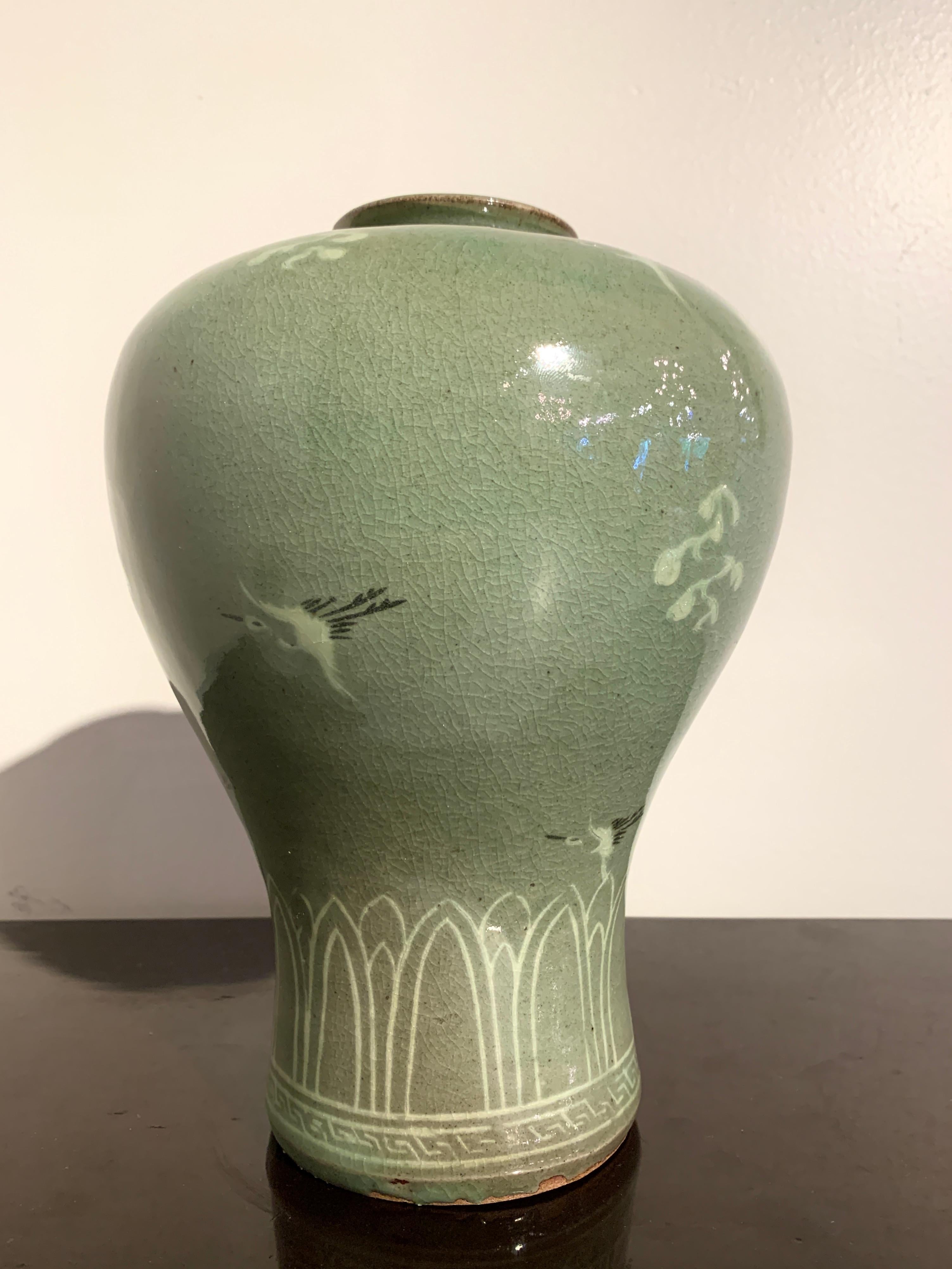 A fine and attractive Korean celadon glazed maebyeong vase with slip inlaid decoration, mid 20th century, Korea.

The elegant vase of somewhat exaggerated maebyeong shape, with a narrow waist, high, bulging shoulders, short neck with wide mouth,