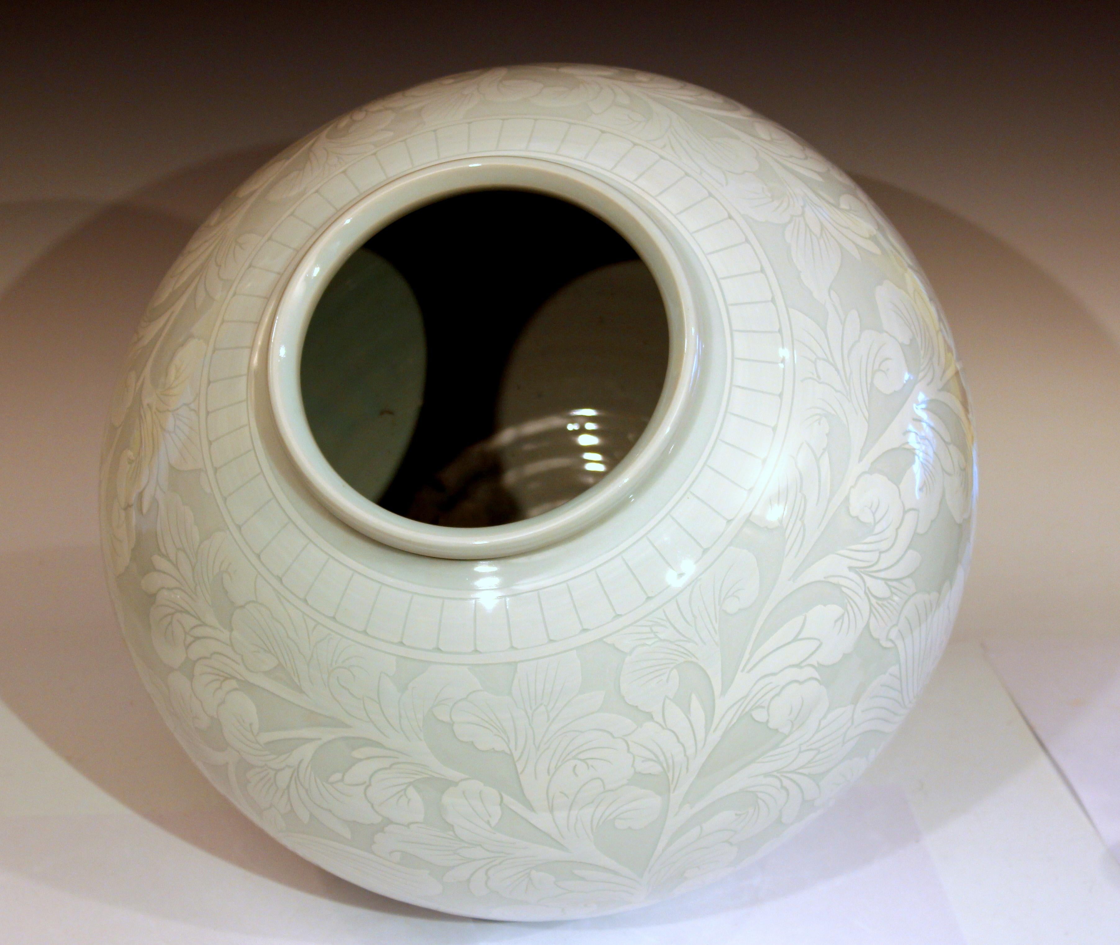 Large Korean studio porcelain moon vase with carved slipware design of a peony scroll. hand-turned and hand decorated. Exceptional design flawlessly executed. Modern. Signed on base. 12” high, 14” diameter. Excellent condition.
