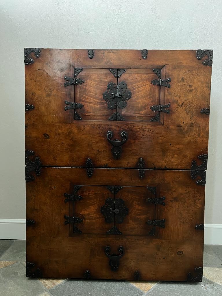 This 19th century Tansu is composed by two overlapping parts. The front has one small door at the center with half-face hinge; the lock can be opened by a key. 
The decorations here are quite sober, there are iron inserts at the corners and small