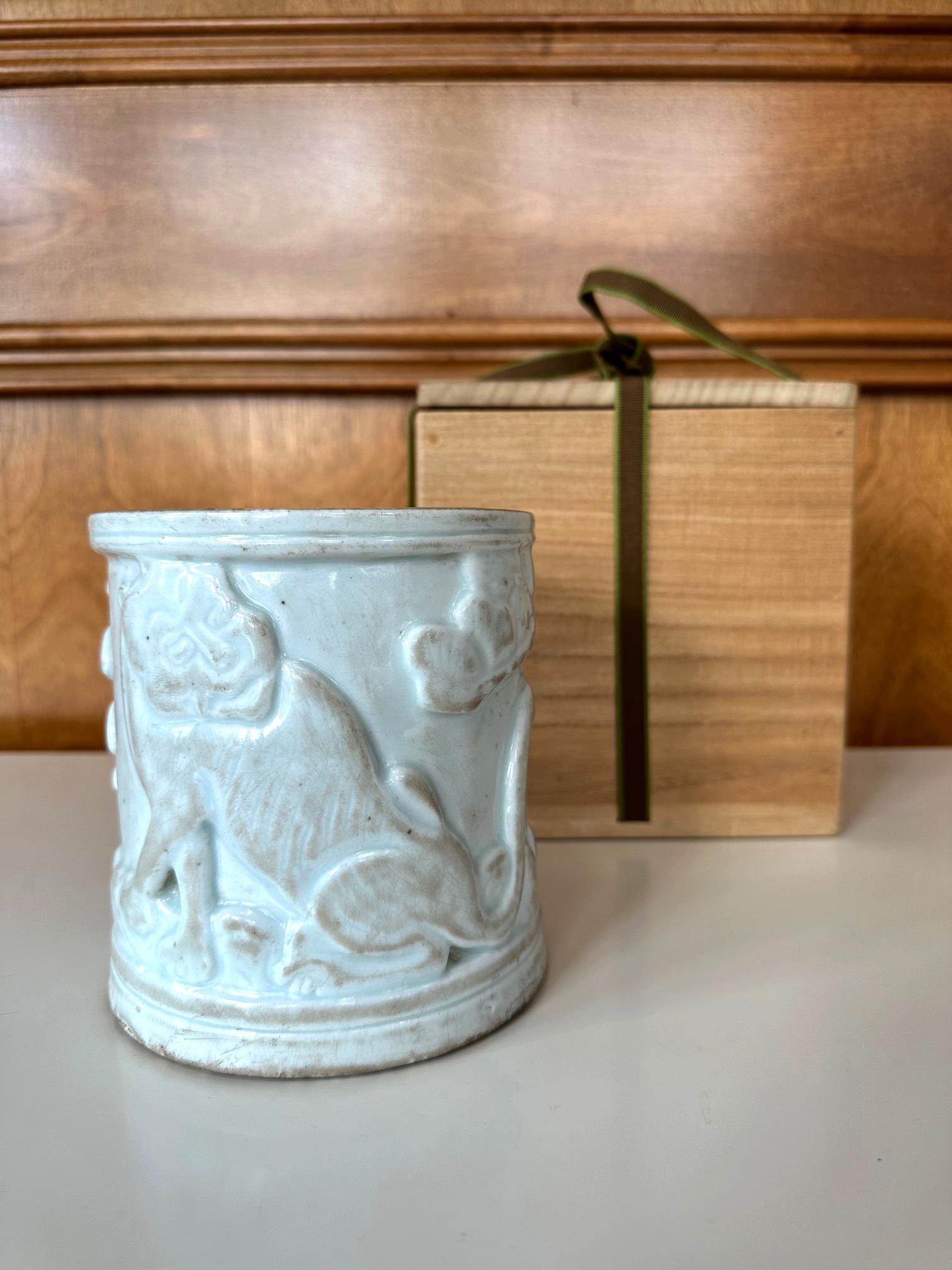 A lovely Korean white porcelain brush holder with carved relief design from late Joseon dynasty (circa 19th century). The brushpot is highlighted with one of the most beloved motifs in Korea, a crouched tiger (Ho). Low relief carving was used to
