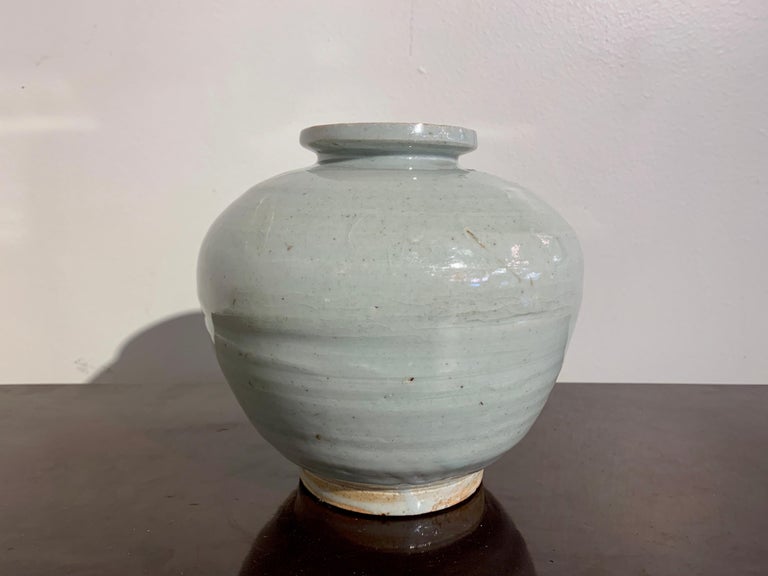 A sublime Korean white glazed porcelain globular jar, Joseon Dynasty, 18th century, Korea.

The squat jar is heavily potted, with a globular body, very short neck, and wide mouth rim, all resting on a recessed ring foot. The jar glazed all over in