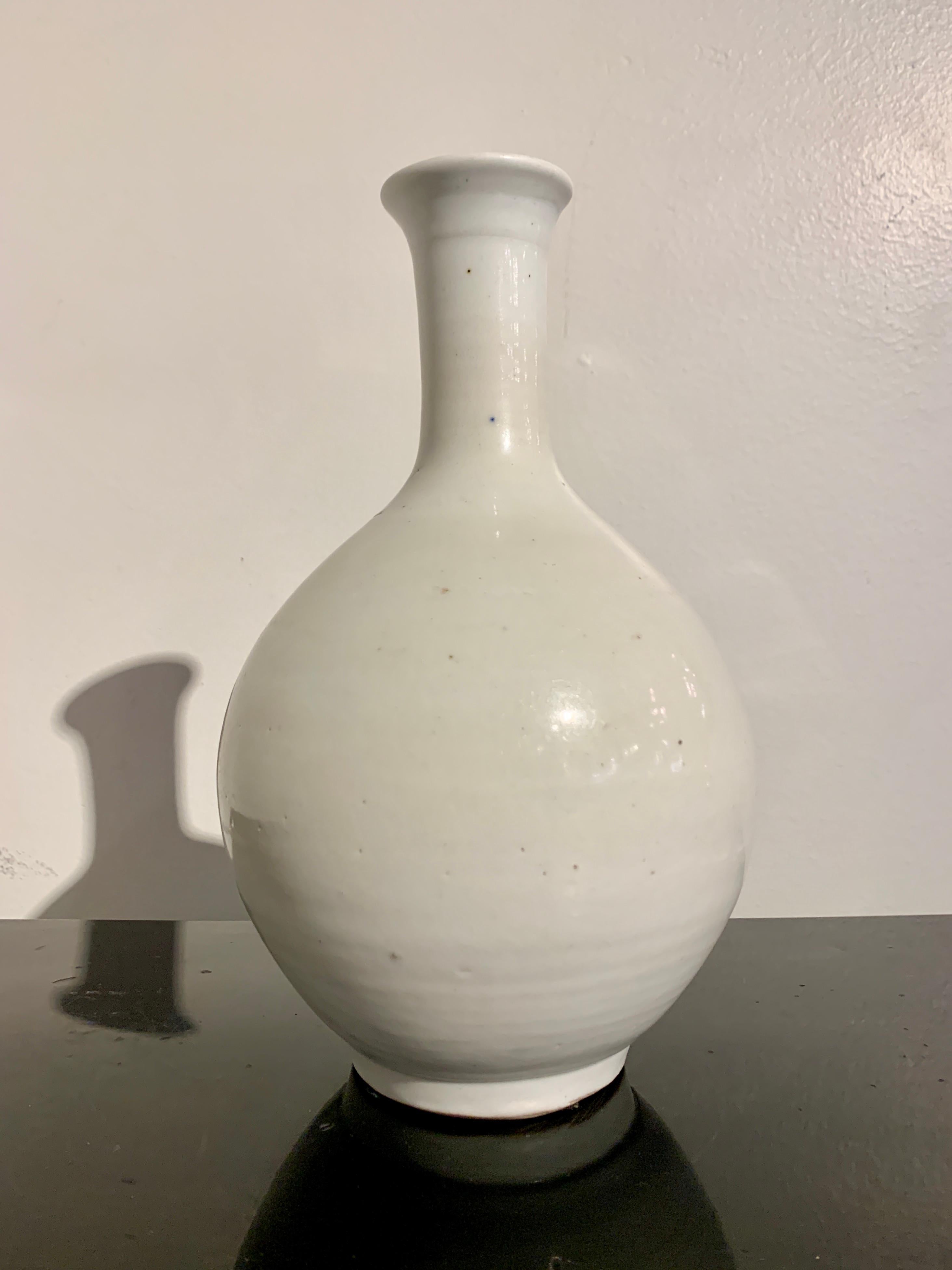 Eine ruhige und elegante koreanische weiß glasierte Flaschenvase, Joseon-Dynastie, Ende 18. Jahrhundert, Korea.

Die zierliche Vase steht auf einem kurzen, vertieften Fuß, hat einen kugelförmigen Körper, einen schmalen Hals und eine leicht nach