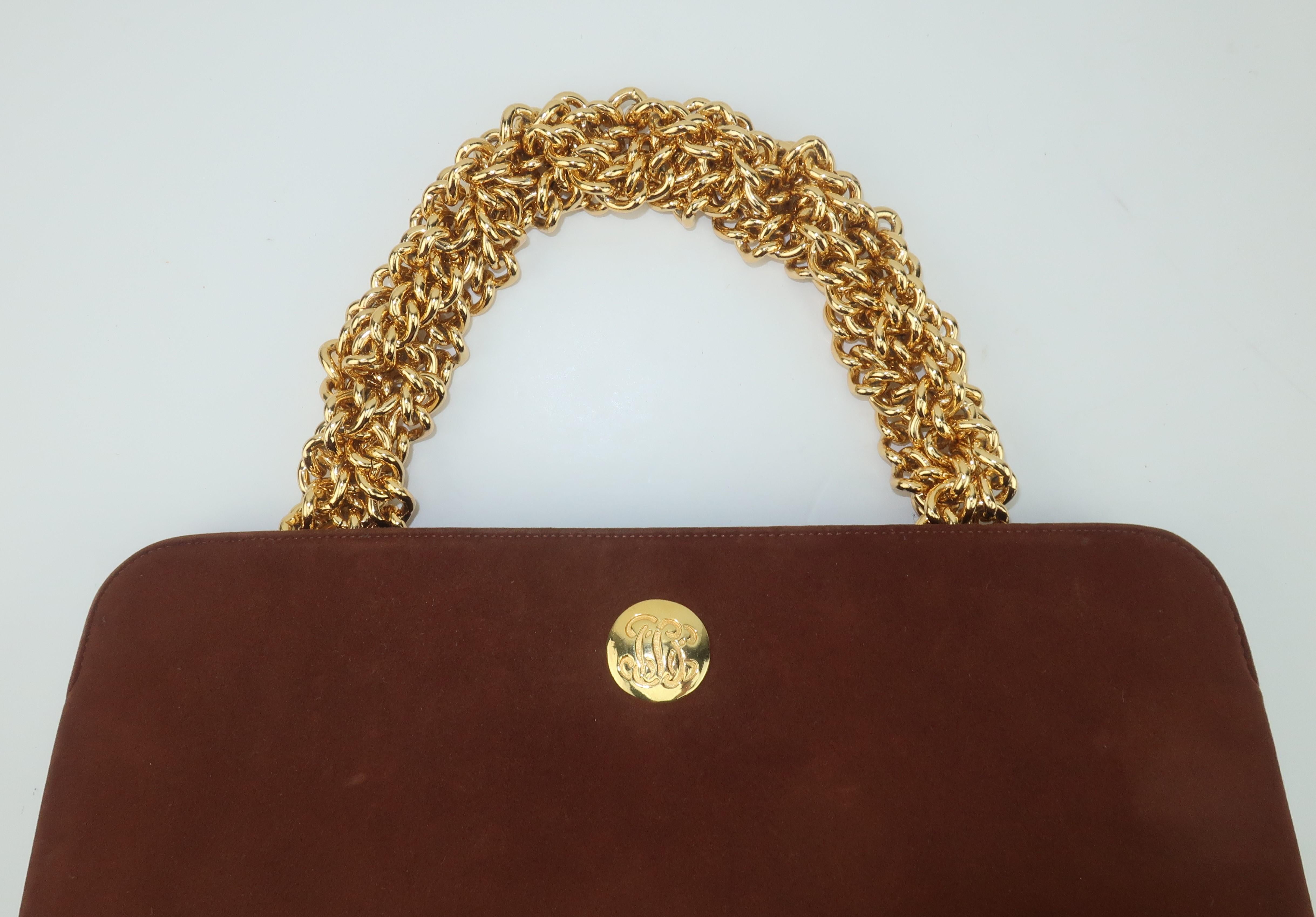 A classic 1960's chocolate brown handbag with a unique chunky gold chain handle fabricated by Koret from their 'non-crockable' or non-shedding kid suede which was coined as 'Koretolope'.  The hidden push button closure opens to reveal a faille