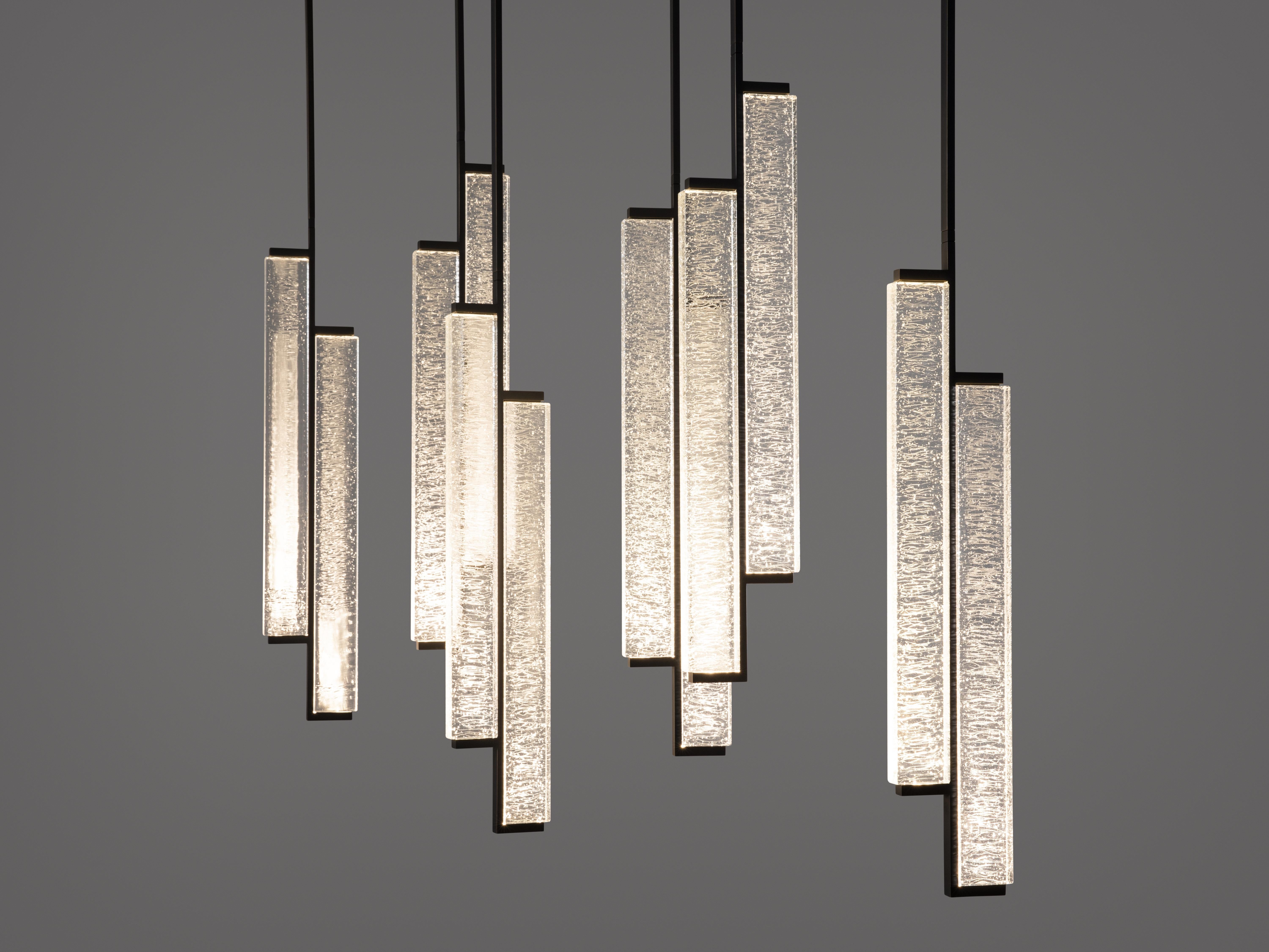 The Kori Chandelier’s cast glass emits a glow reminiscent of dripping icicles at night, inspiring its name which means “ice” in Japanese. The individual pendant units can rotate in a range of angles and positions to best highlight both the space and