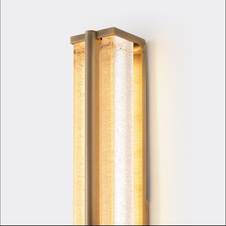 The wonderfully textured cast glass of the Kori Sconce emits a glow reminiscent of dripping icicles at night, inspiring its name which means “ice” in Japanese. These textures are complemented by a minimalist brass frame designed to support the glass