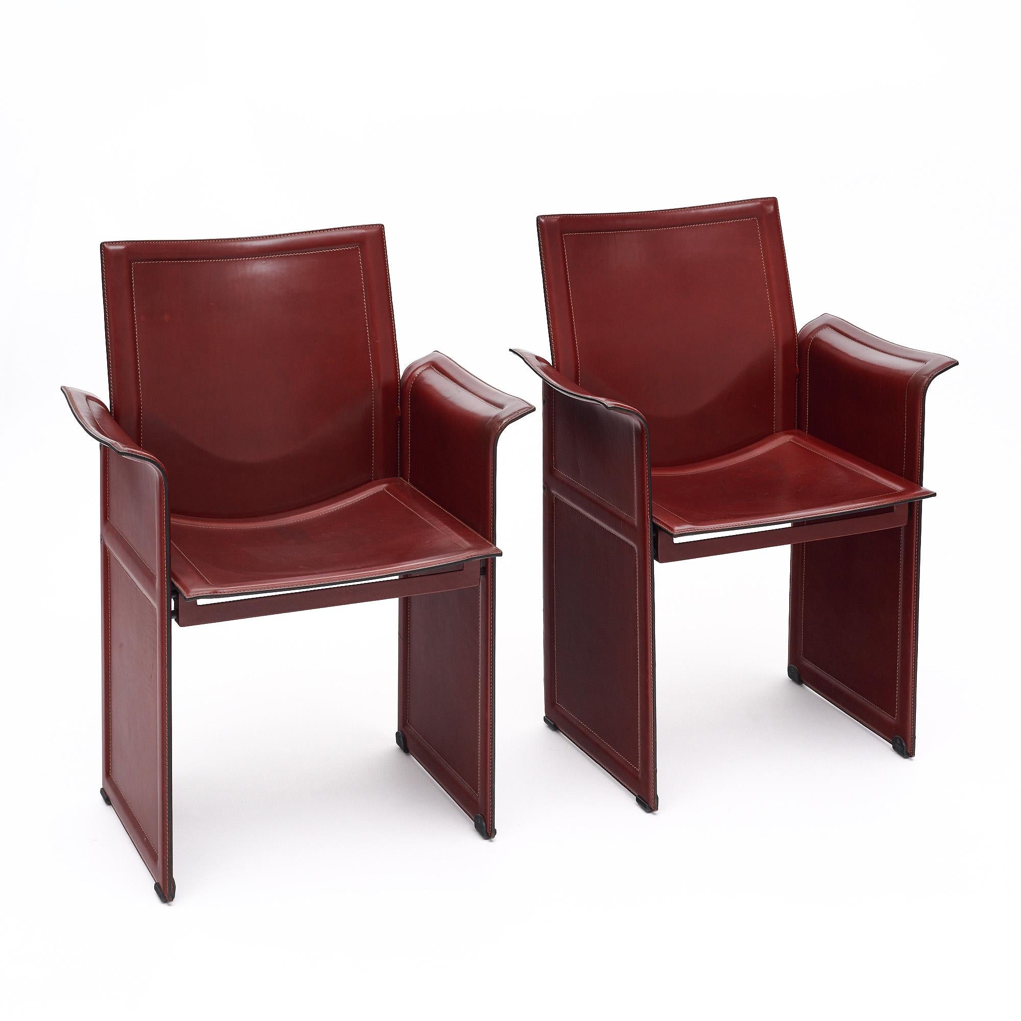 Pair of armchairs by Tito Agnoli designed for Matteo Grassi in 1979. These Italian chairs feature a metal frame and high-quality stitched leather in a warm burgundy tone. They are very comfortable and stable. We especially love the beautiful