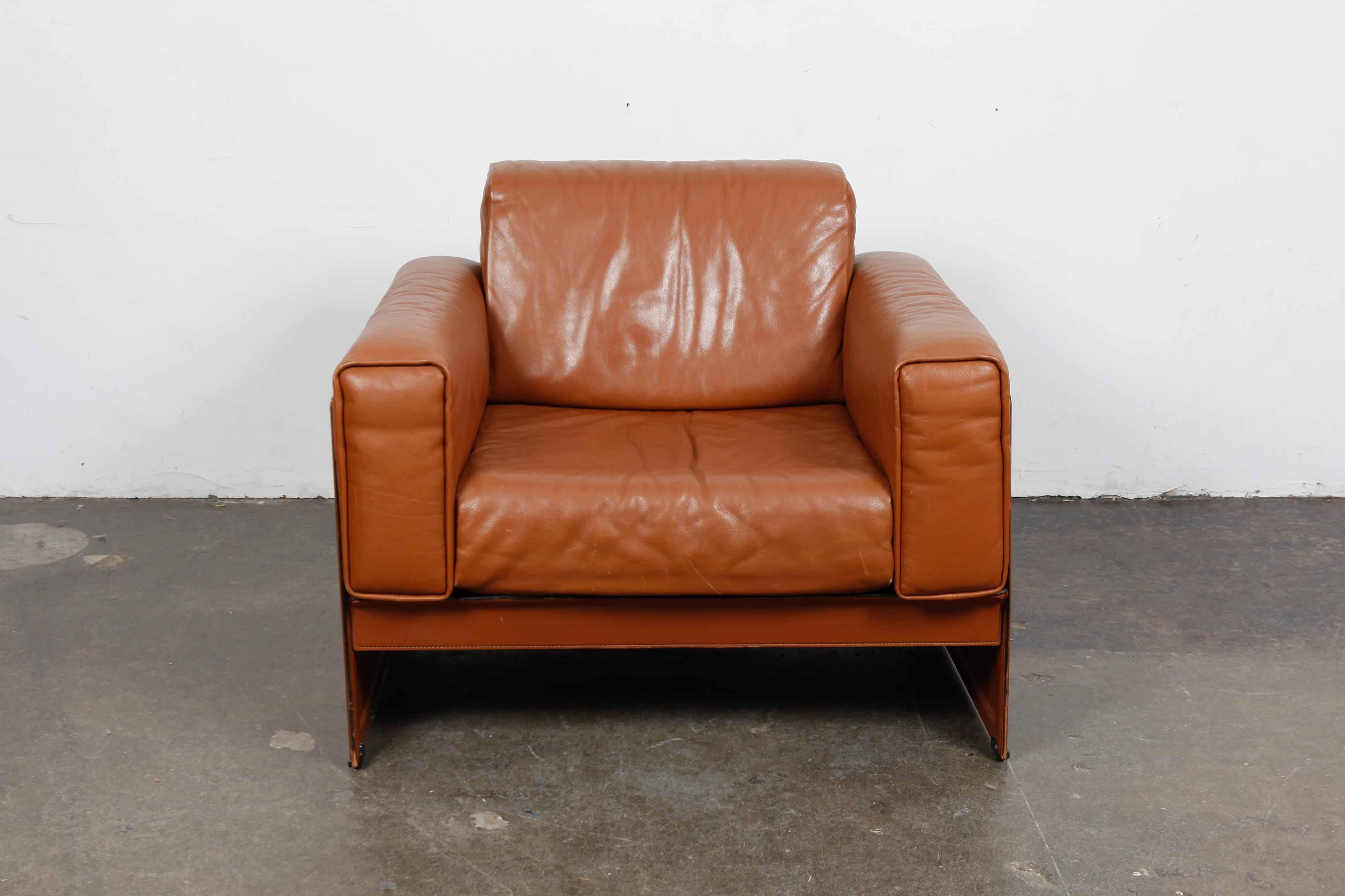 Original cognac leather 'Korium' lounge chairs by Tito Agnoli for Matteo Grassi, designed in 1980. Frame of the chair is steel covered completely in leather, really beautiful chair in original leather.