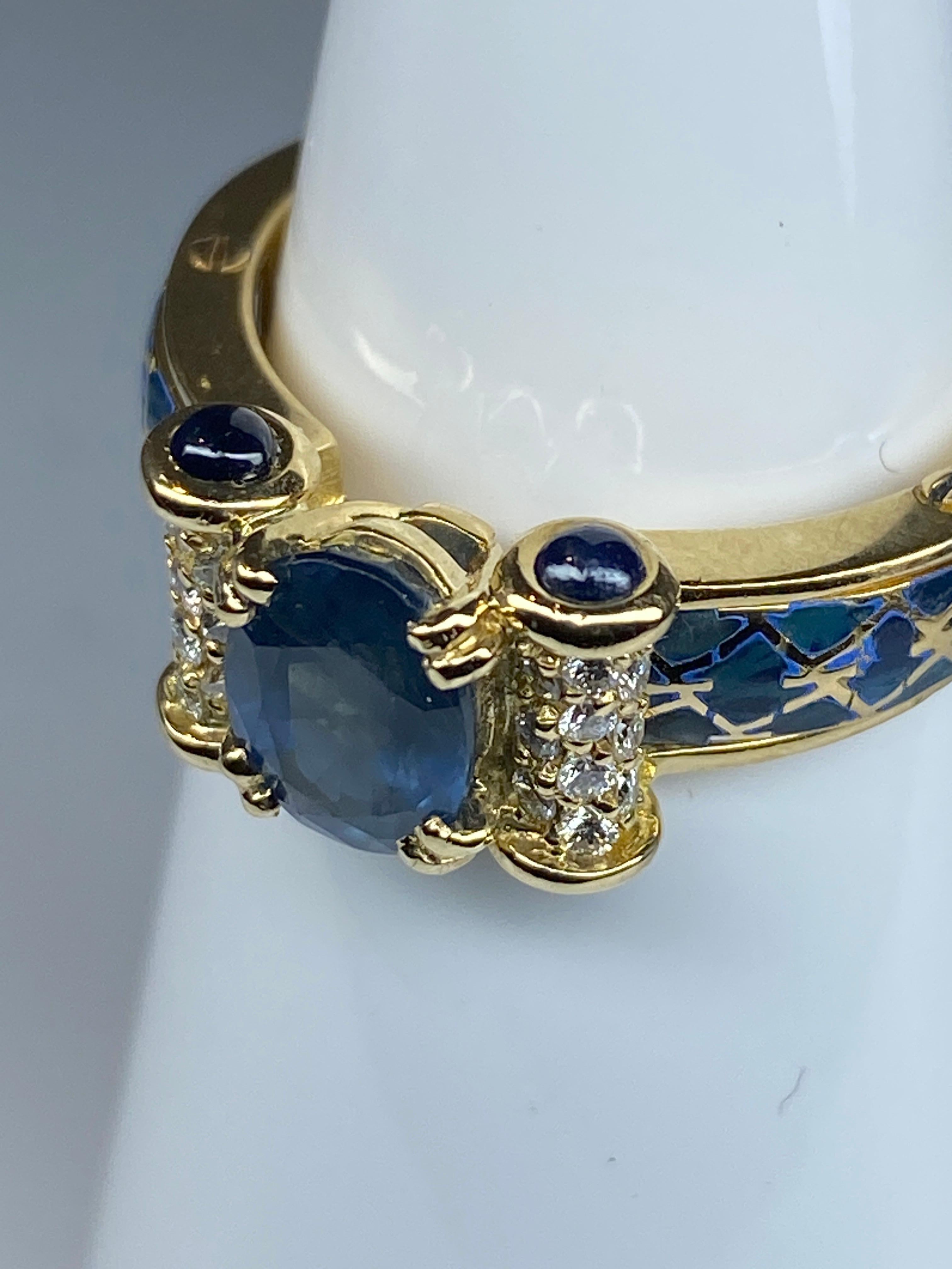 Ein ovaler Saphir von schöner blauer Farbe, der 1,71 Karat wiegt, ziert die 18-karätige Kugel in der Mitte. Er ist mit 2 Diamantenpavés mit jeweils 10 Diamanten besetzt, Gewicht der Diamanten ca. 0,20 Karat. Jedes Rouleau ist an den Außenseiten mit