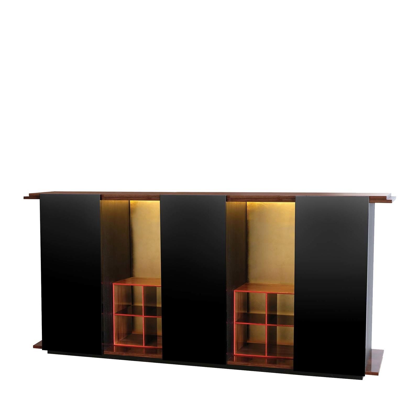 Defined by an intriguing combination of open and closed spaces, this cabinet's distinctive character embodies a precise harmony of contrasts. Framed in a top and base in Canaletto walnut, the three cabinets with glossy black polyurethane lacquer are