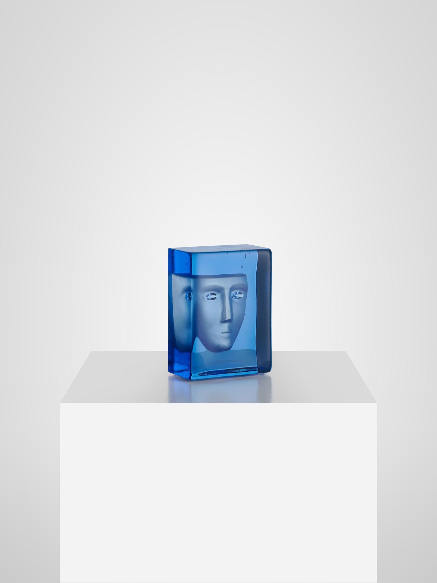 The renowned Swedish glass artist Bertil Vallien has created Azur Frost. It is an exclusive art object in blue glass, cast in a charcoal mold, with a sandblasted imprint of a face. The face is a recurring Bertil Vallien motif – one of his