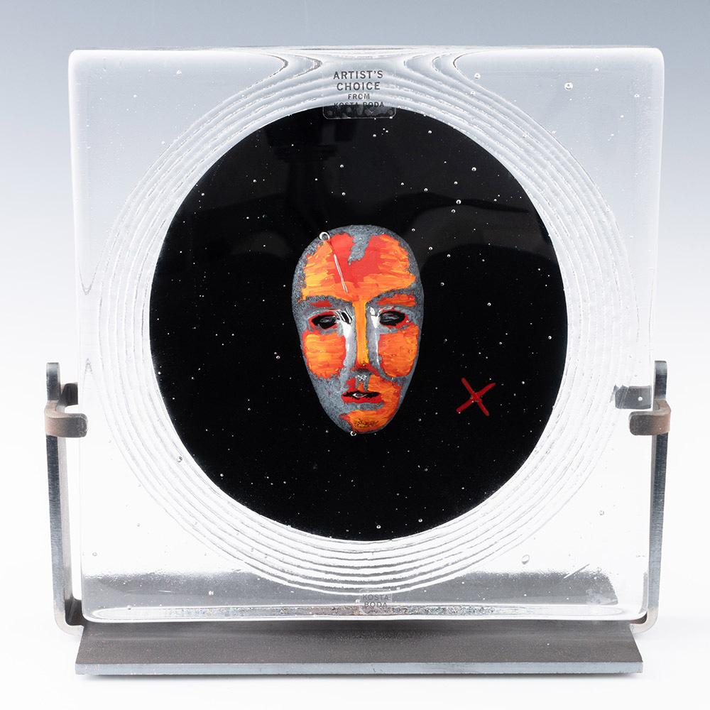 Heading : Kosta Boda Bertil Vallien Black Moon face plaque
Date : 2008
Origin : Sweden
Features : Clear glass casing with black centre featuring a grey and blood orange mask with controlled bubbles. Metal mount.
Marks : Signed to base along with